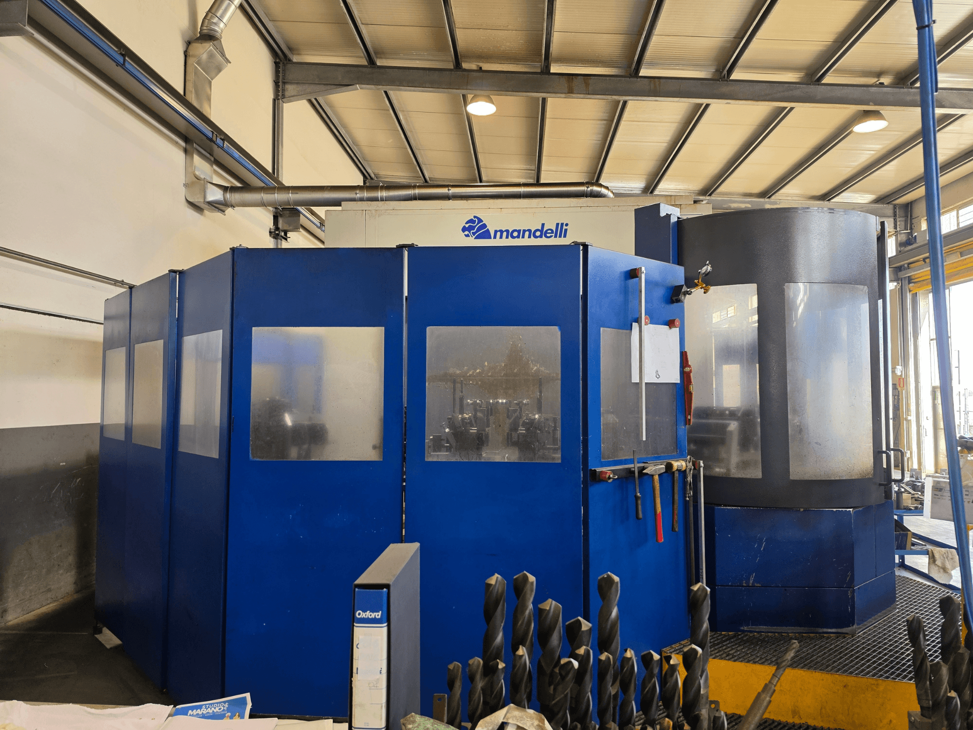 Vooraanzicht van een Mandelli STORM 1400 horizontaal bewerkingscentrum, met blauwe behuizing en gemonteerde gereedschappen.