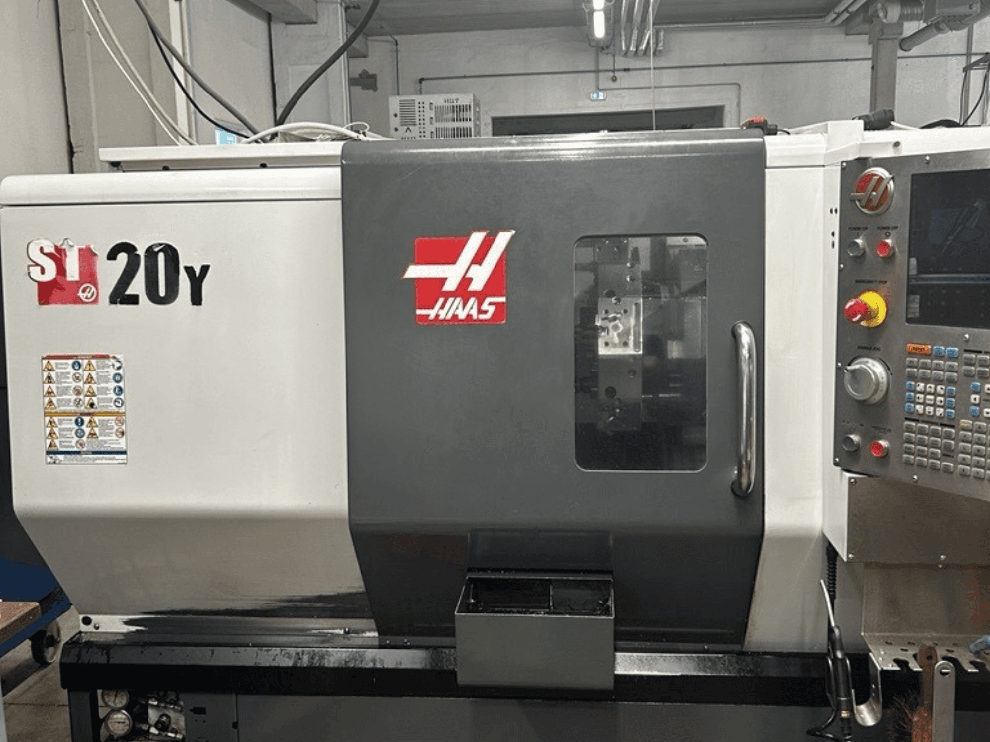 Haas ST-20Y CNC draaibank, vooraanzicht, met bedieningspaneel, veiligheidslabels en werkvenster.