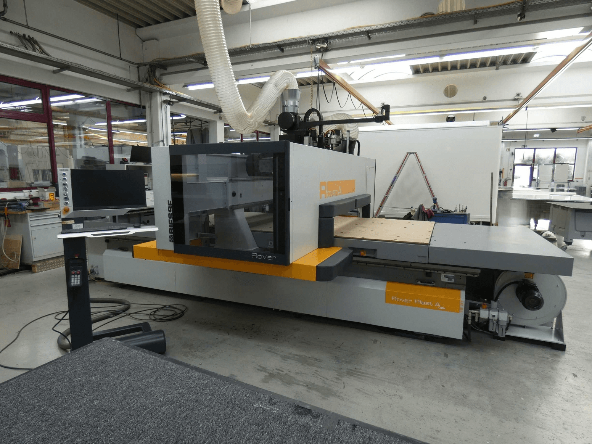 Vooraanzicht van het BIESSE ROVER PLAST A FT 1224 CNC-bewerkingscentrum voor hout, met zichtbare monitor en bedieningspaneel.