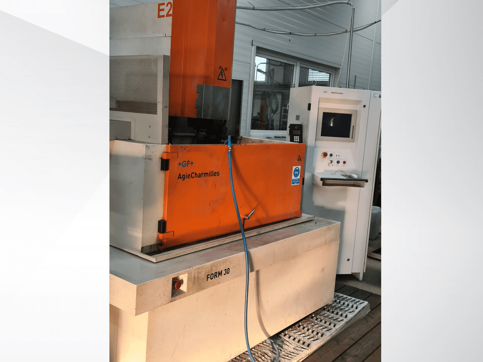 AgieCharmilles FORM 30 zink-EDM-machine, vooraanzicht, met oranje schakelkast en zichtbare waterslang.