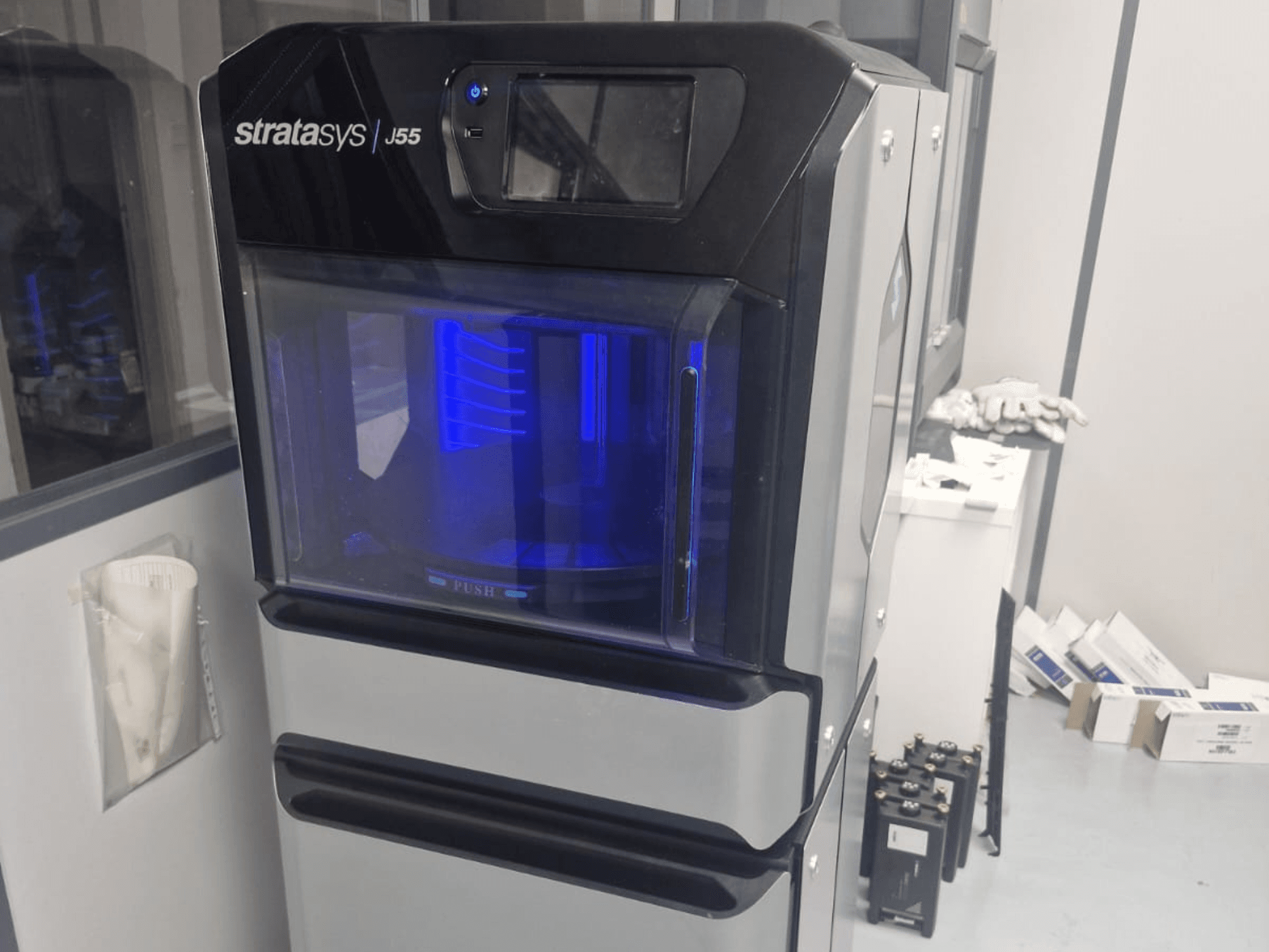 Stratasys J55 Prime plastic 3D printer in zijaanzicht, met het slanke ontwerp en het verlichte printgebied.