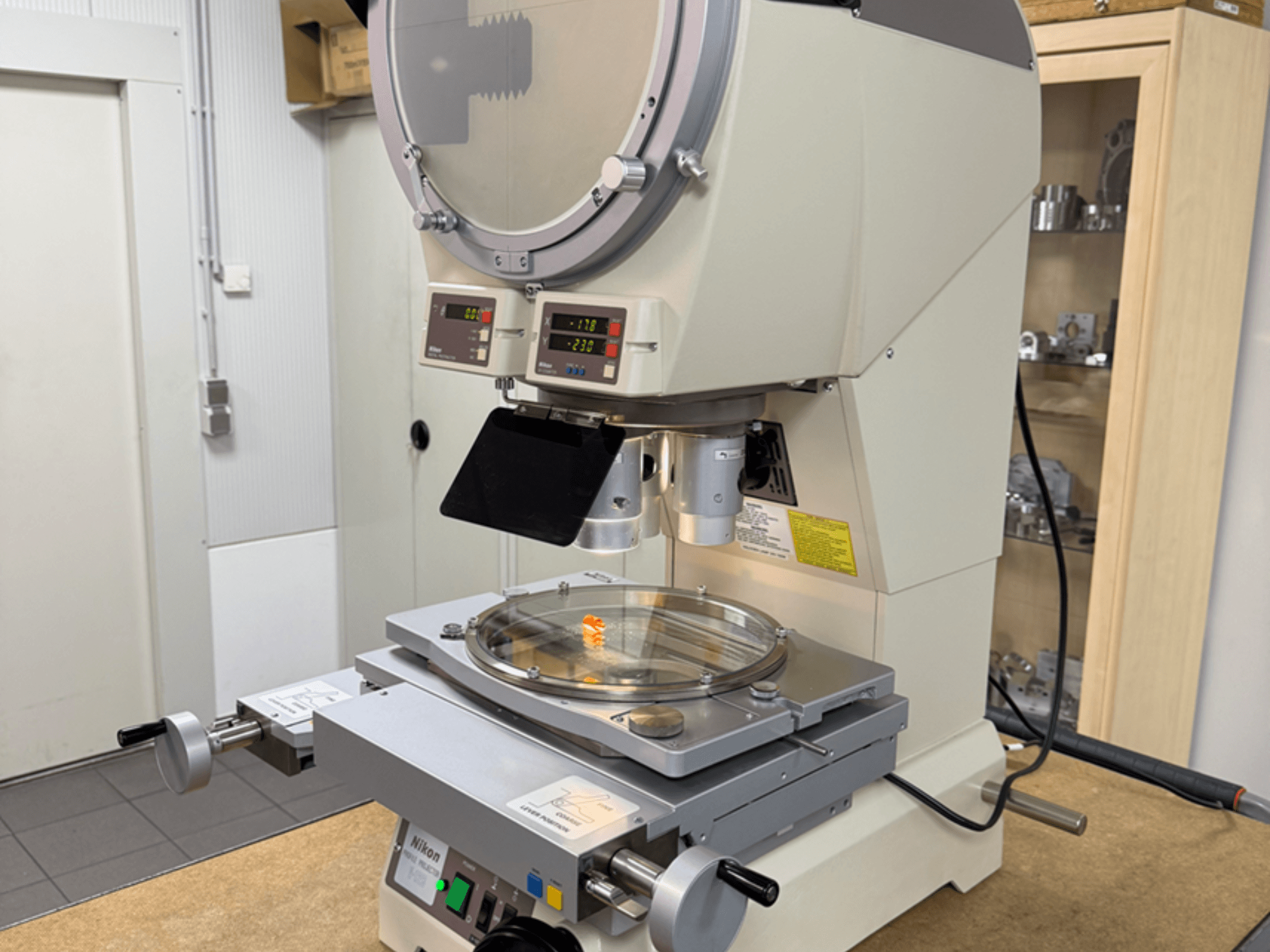 Nikon-model microscoop in vooraanzicht, met digitale displays, een verstelbare tafel en een ronde glasplaat.