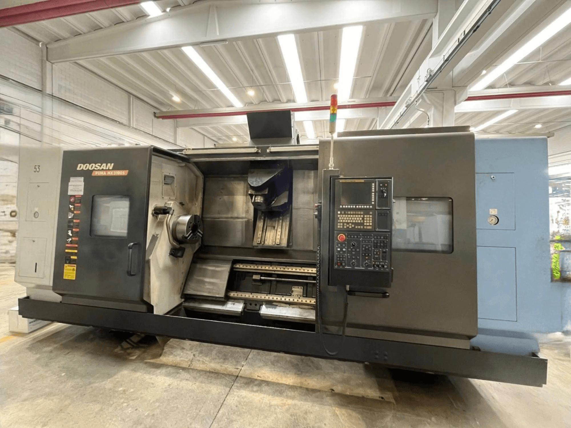 Vooraanzicht van een DOOSAN PUMA MX3100 horizontale draaimachine met bedieningspaneel en zichtbare spil en gereedschapshouder.