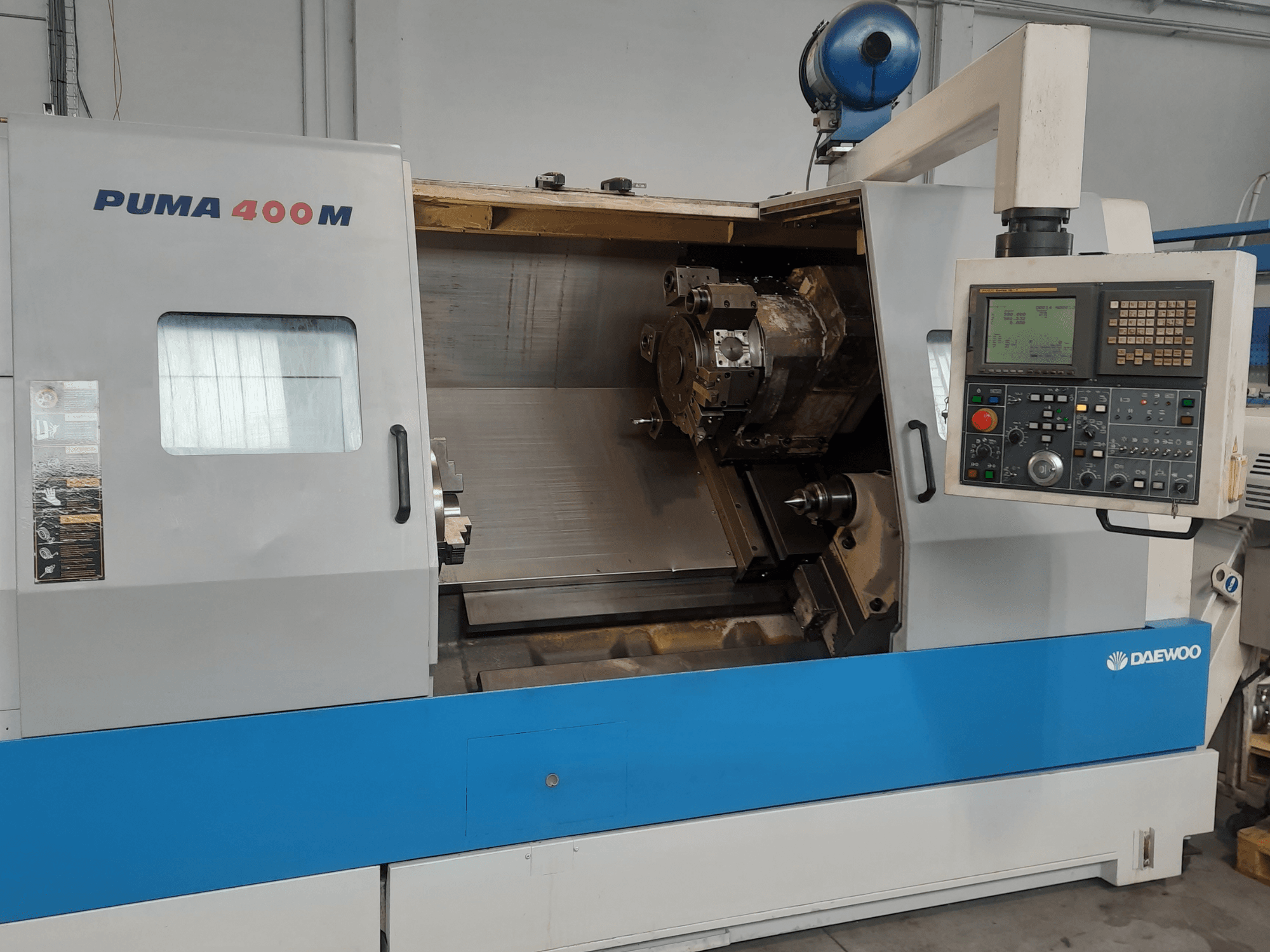 Vooraanzicht van een DAEWOO PUMA 400MB horizontale draaimachine, met de bedieningselementen en het snijgereedschap in de kamer.