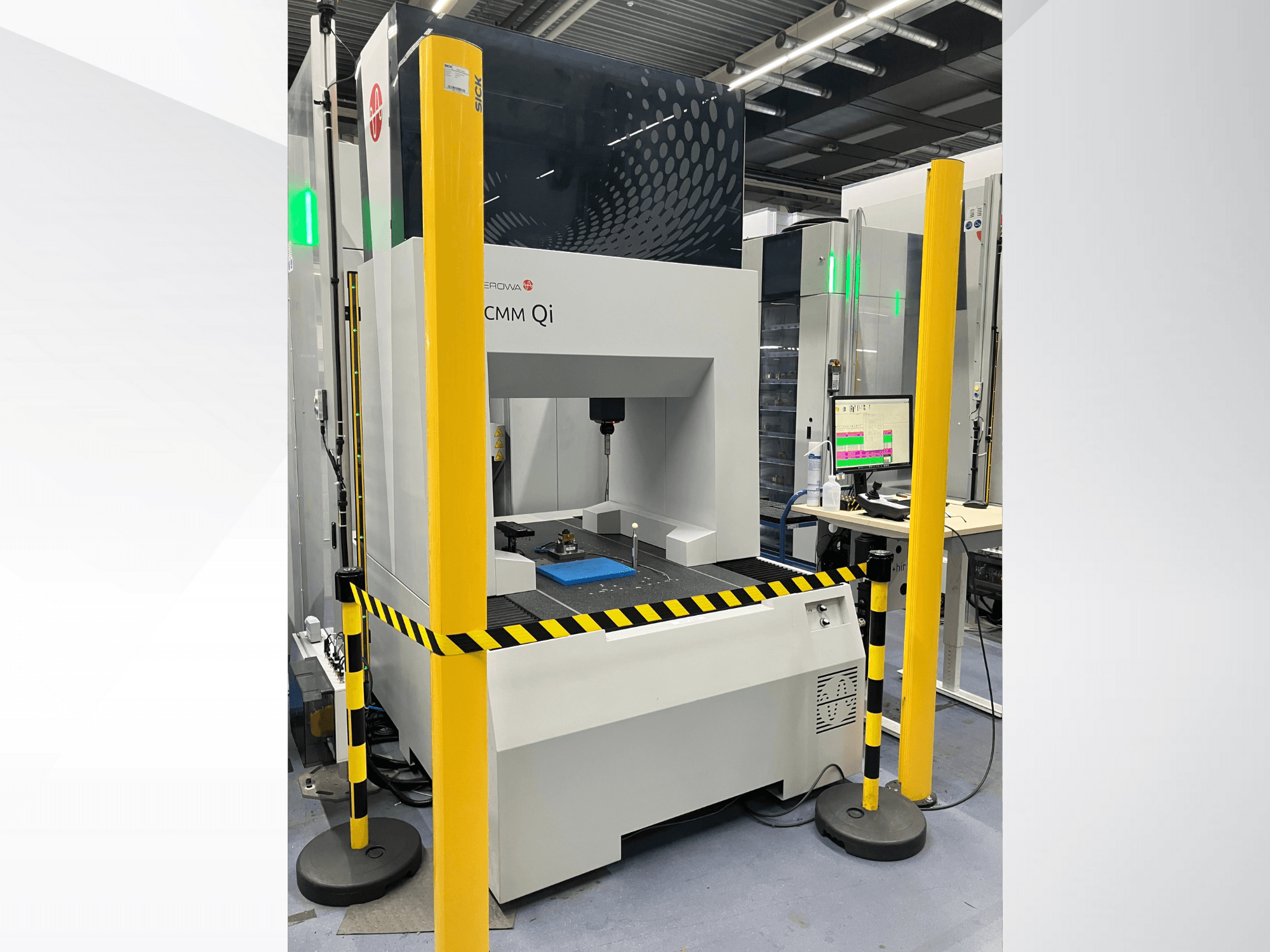 CMM Qi coördinaten meetmachine van Aerovent, vooraanzicht met veiligheidshekken en monitor die meetgegevens weergeeft.