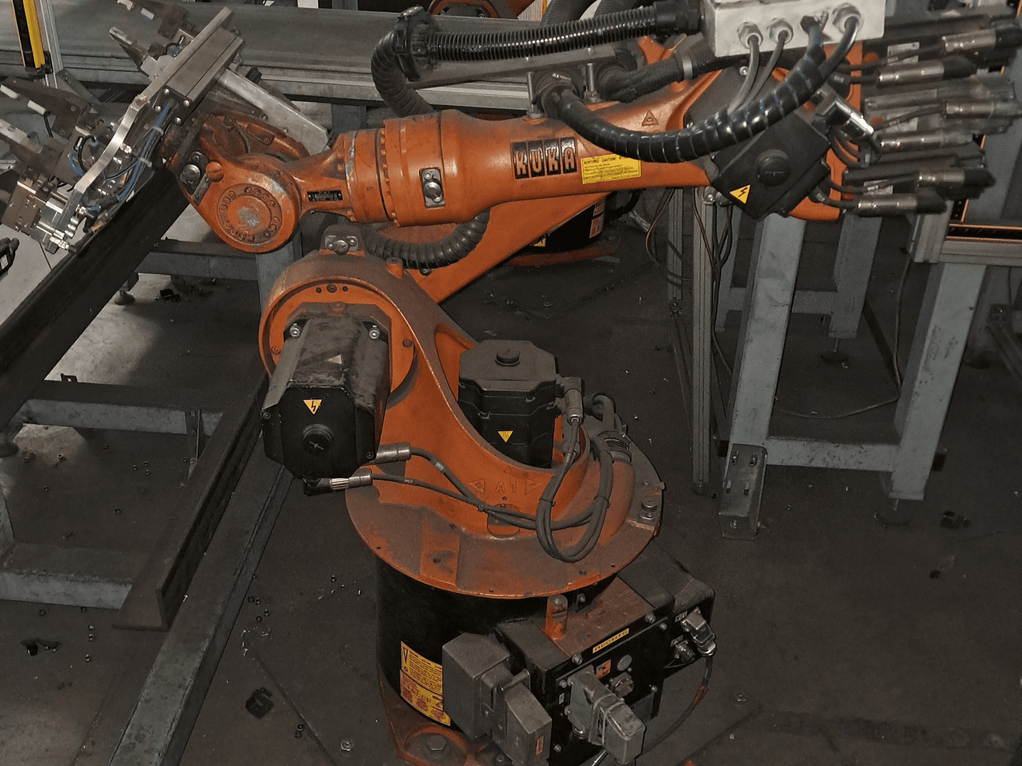 De KUKA KR 16-2-robotarm gezien van bovenaf, waarbij de oranje behuizing, de motor en de mechanische onderdelen goed te zien zijn.