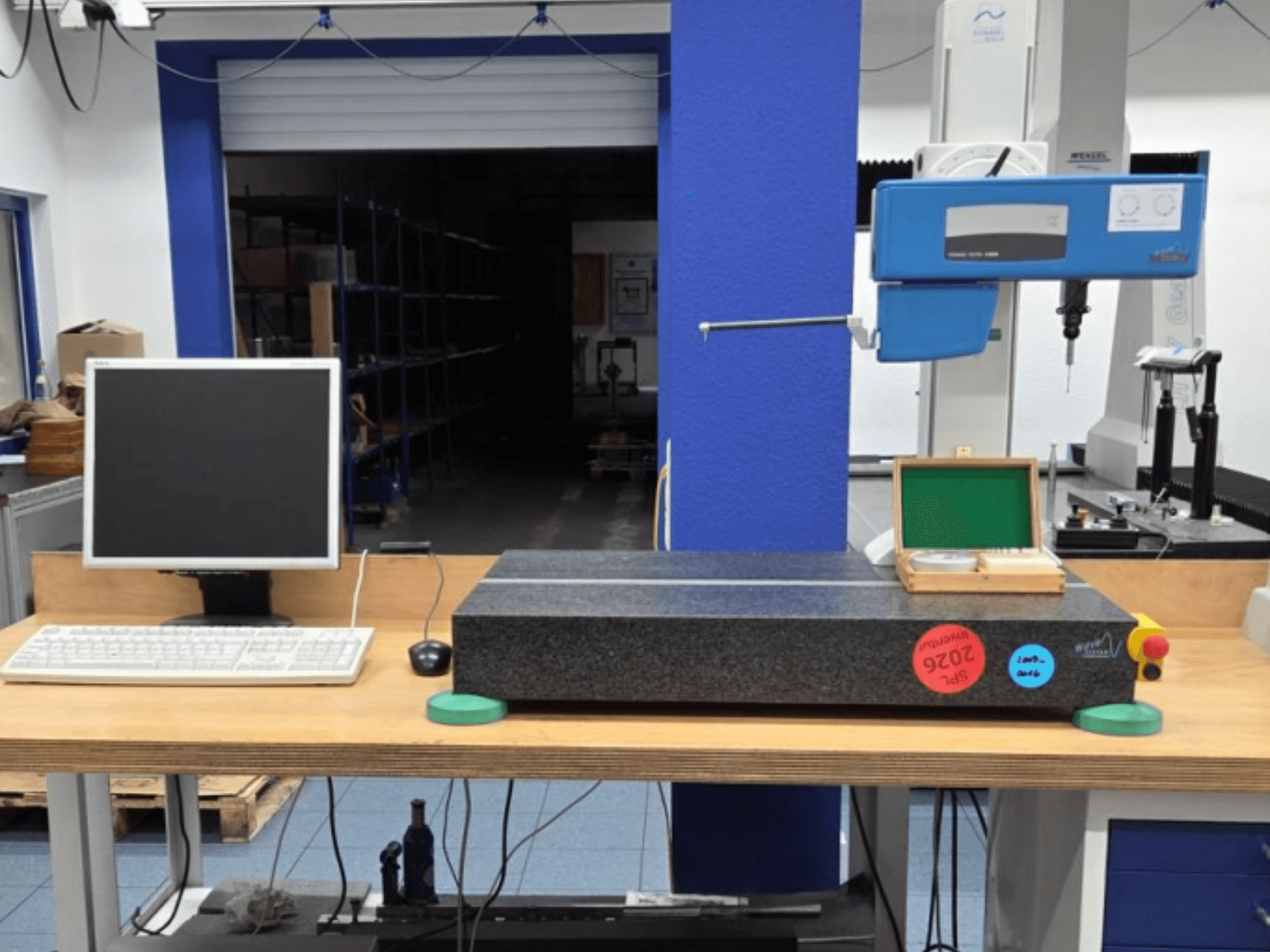 JENOPTIK wave C8000 CMM in een werkplaats, met monitor, toetsenbord en granieten meetvlak. Vooraanzicht.