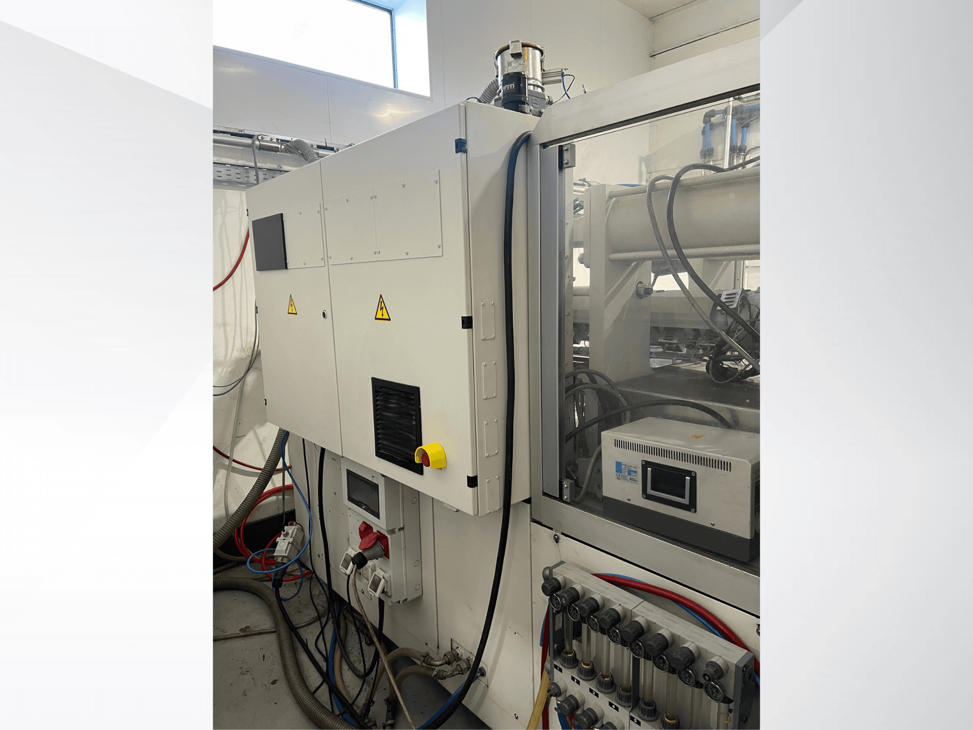 Krauss Maffei 125-520 C1 hydraulische spuitgietmachine, zijaanzicht met bedieningspaneel en hydraulische aansluitingen.