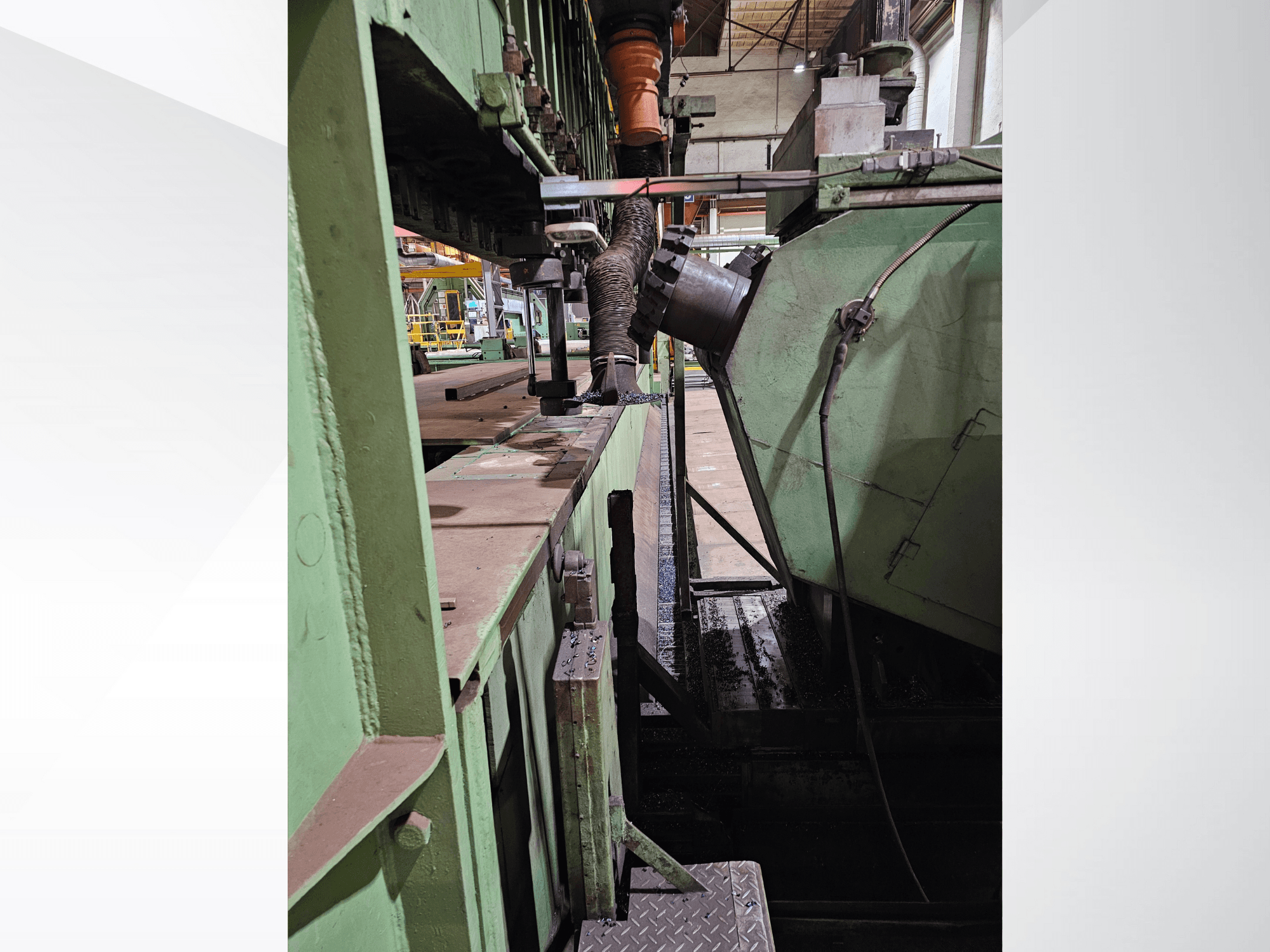 Groene industriële machines met een zijaanzicht van een trechter en toevoermechanisme, met metalen onderdelen en een platform.