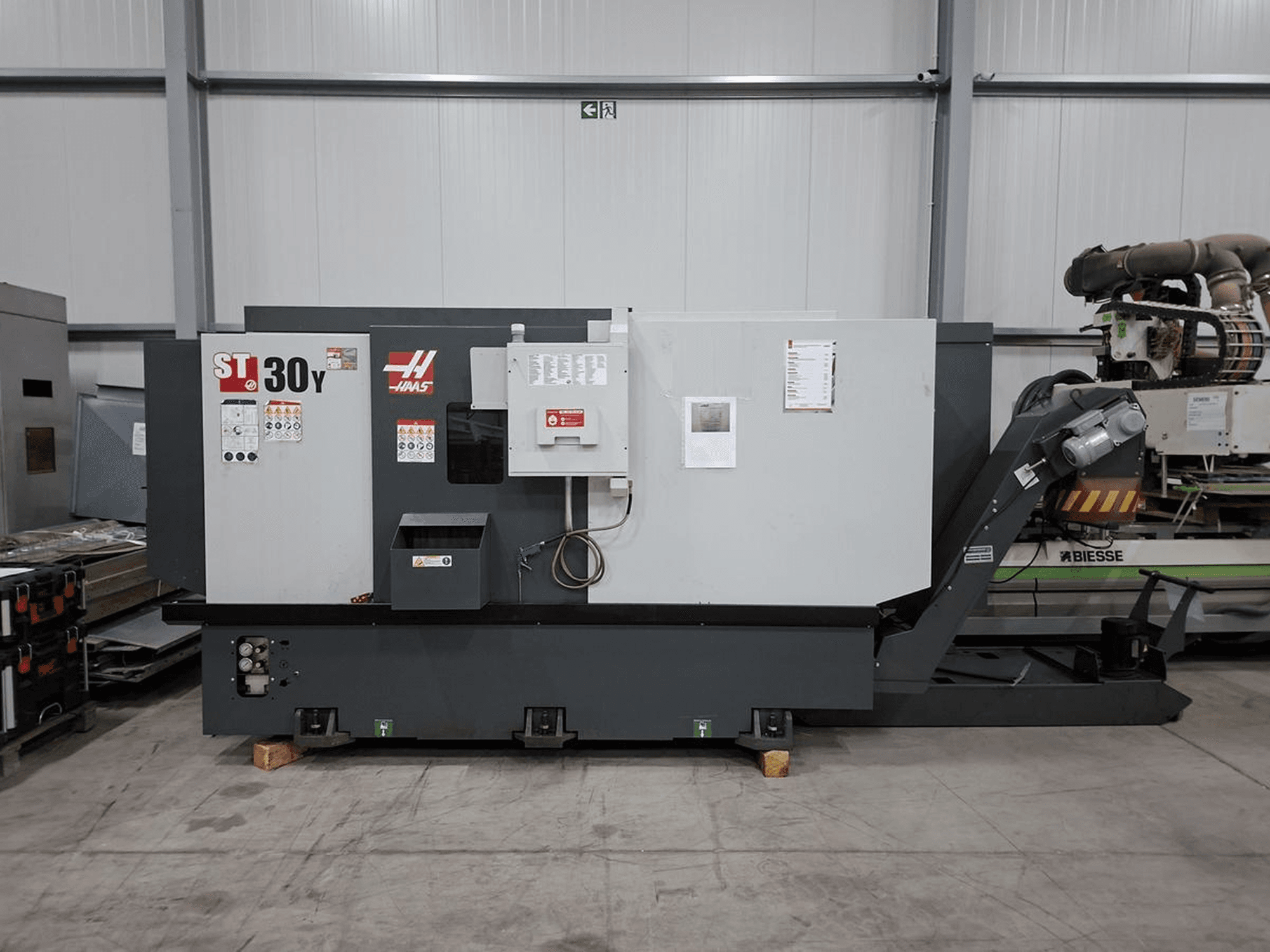 Haas ST-30Y horizontale draaimachine in zijaanzicht, met zicht op de bedieningselementen, labels en de robuuste constructie in een ruime werkplaats.