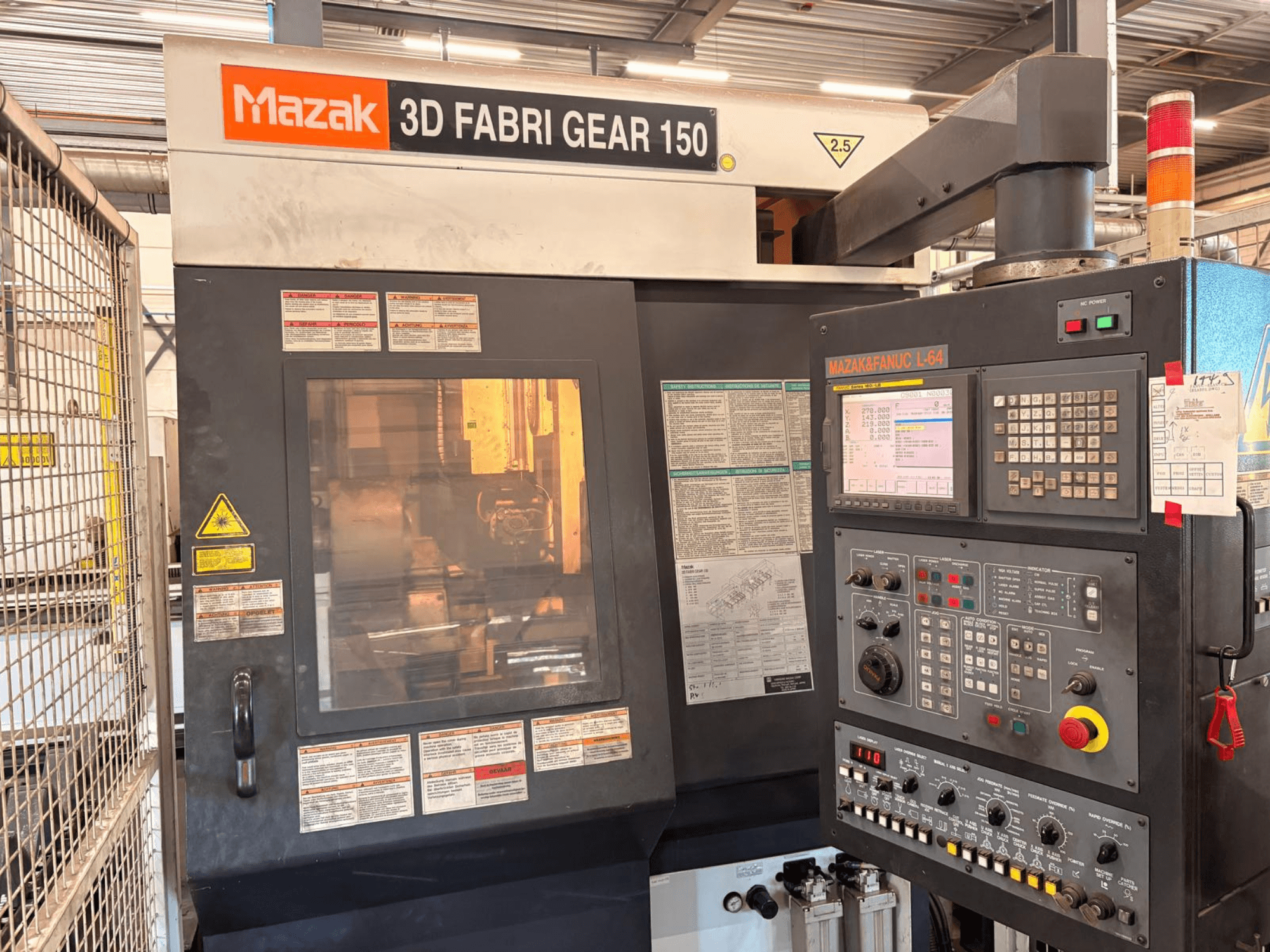 Mazak 3D Fabri Gear 150 buizensnijmachine, vooraanzicht met bedieningspaneel, veiligheidslabels en bedieningsinterface.
