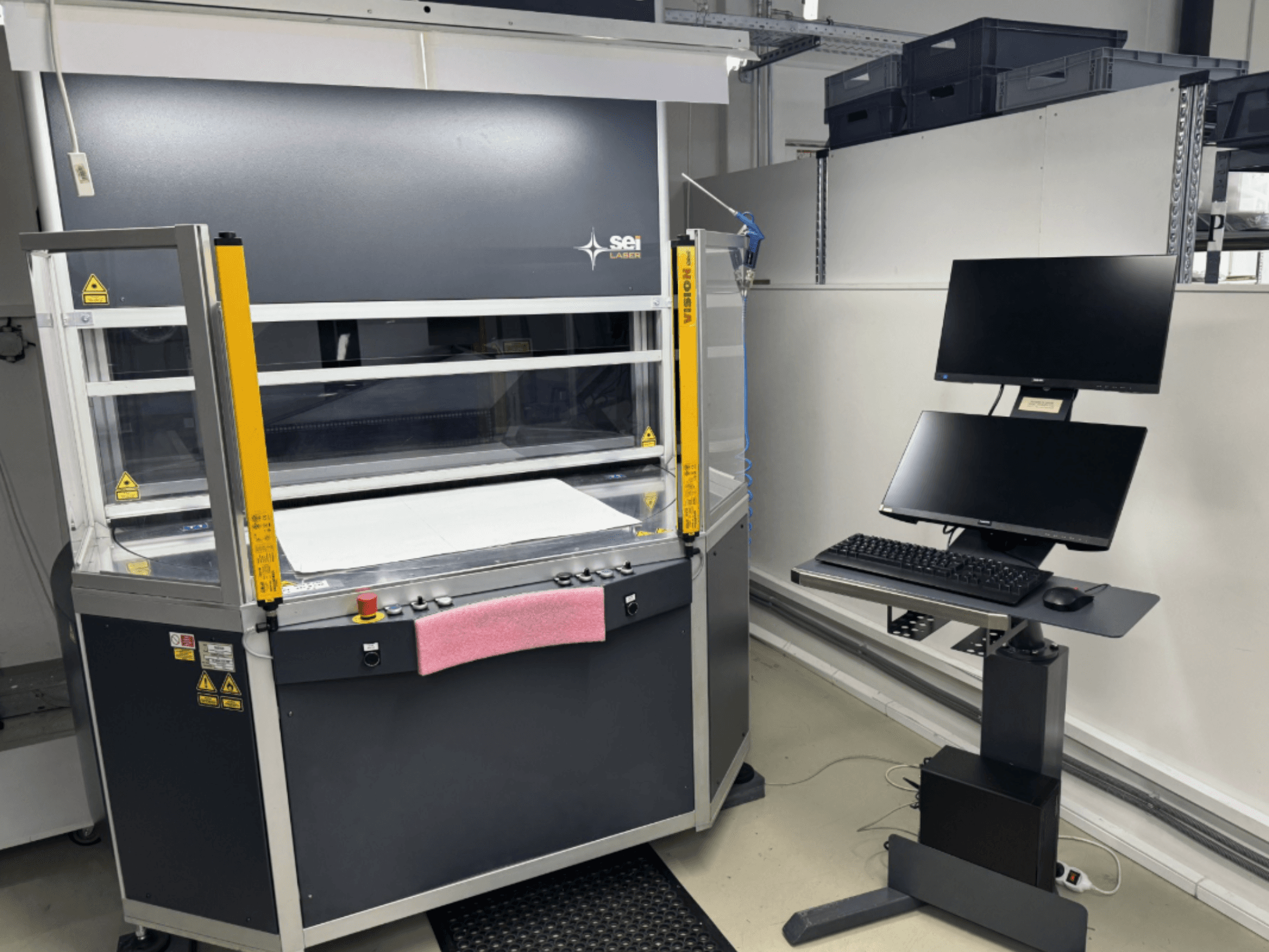 SEI Laser INFINITY 5070 V300 CO₂-lasersnijmachine in vooraanzicht, met bedieningspaneel en aangesloten monitorstation.
