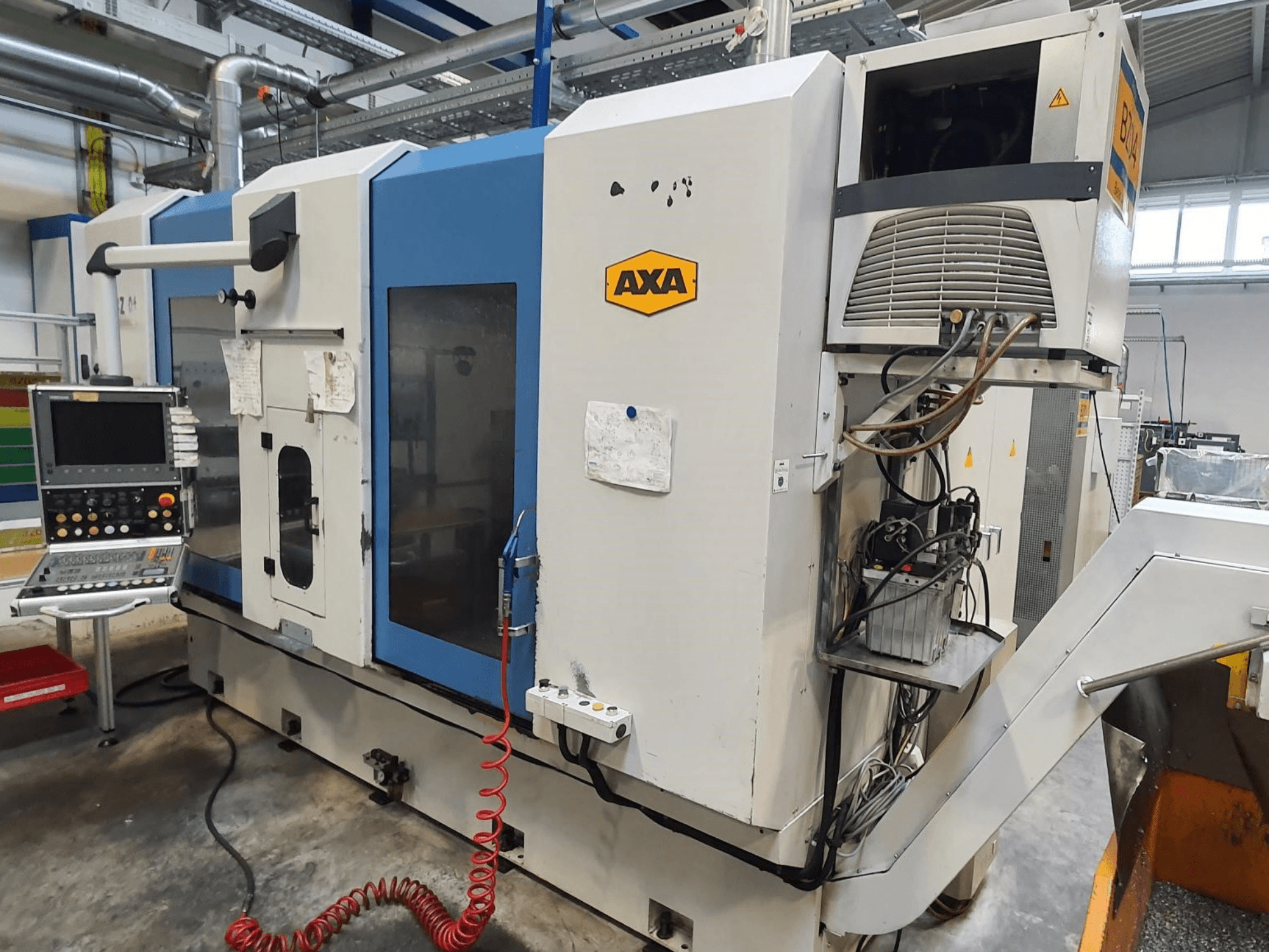 AXA DBZ verticaal bewerkingscentrum, vooraanzicht, met bedieningspaneel en zichtbaar detail van het koelsysteem.