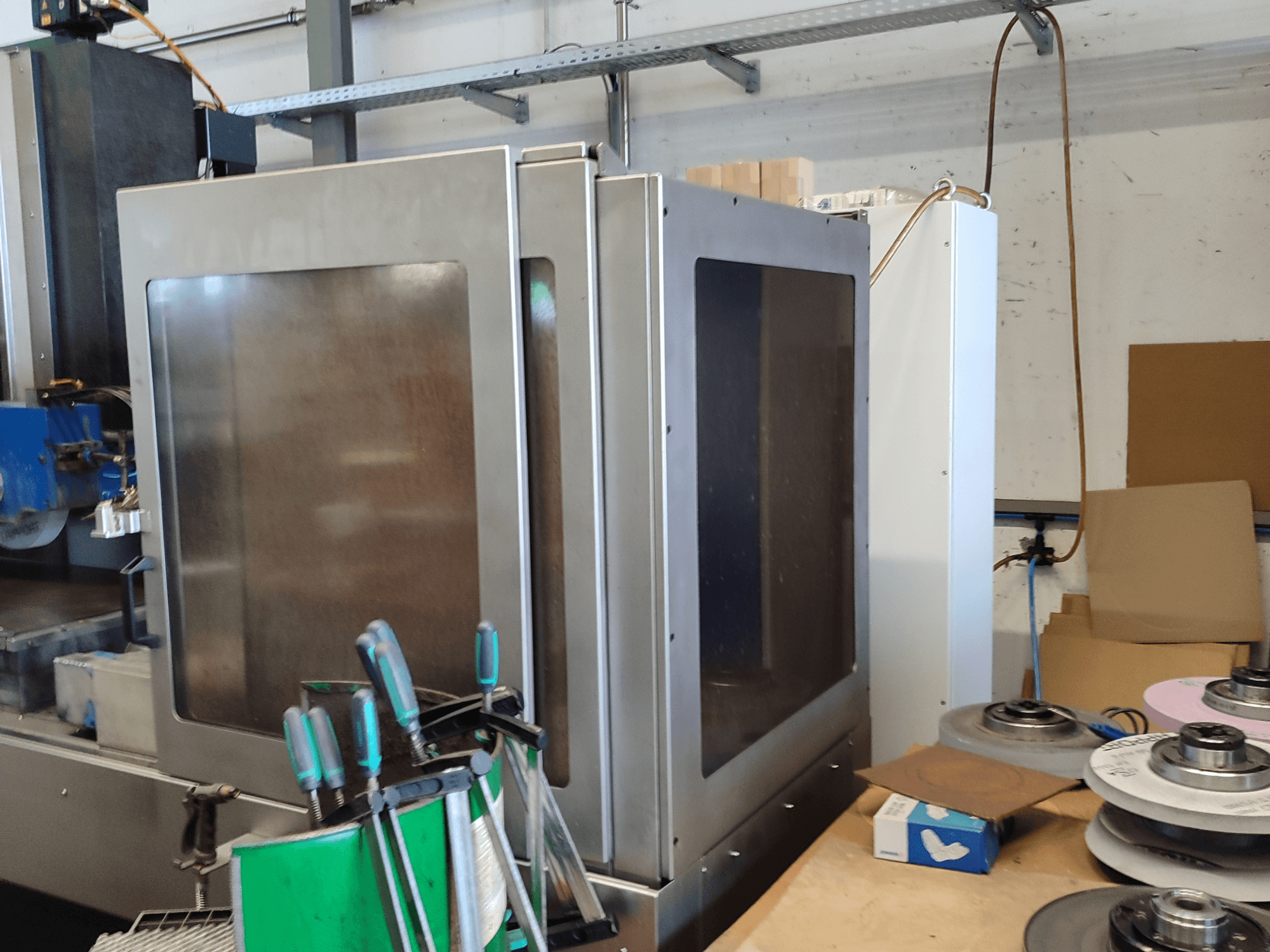 HEINZ STÖCKEL vlakslijpmachine FD 1560 NC-T, zijaanzicht met metalen behuizing en slijpcomponenten in werkplaatsopstelling.