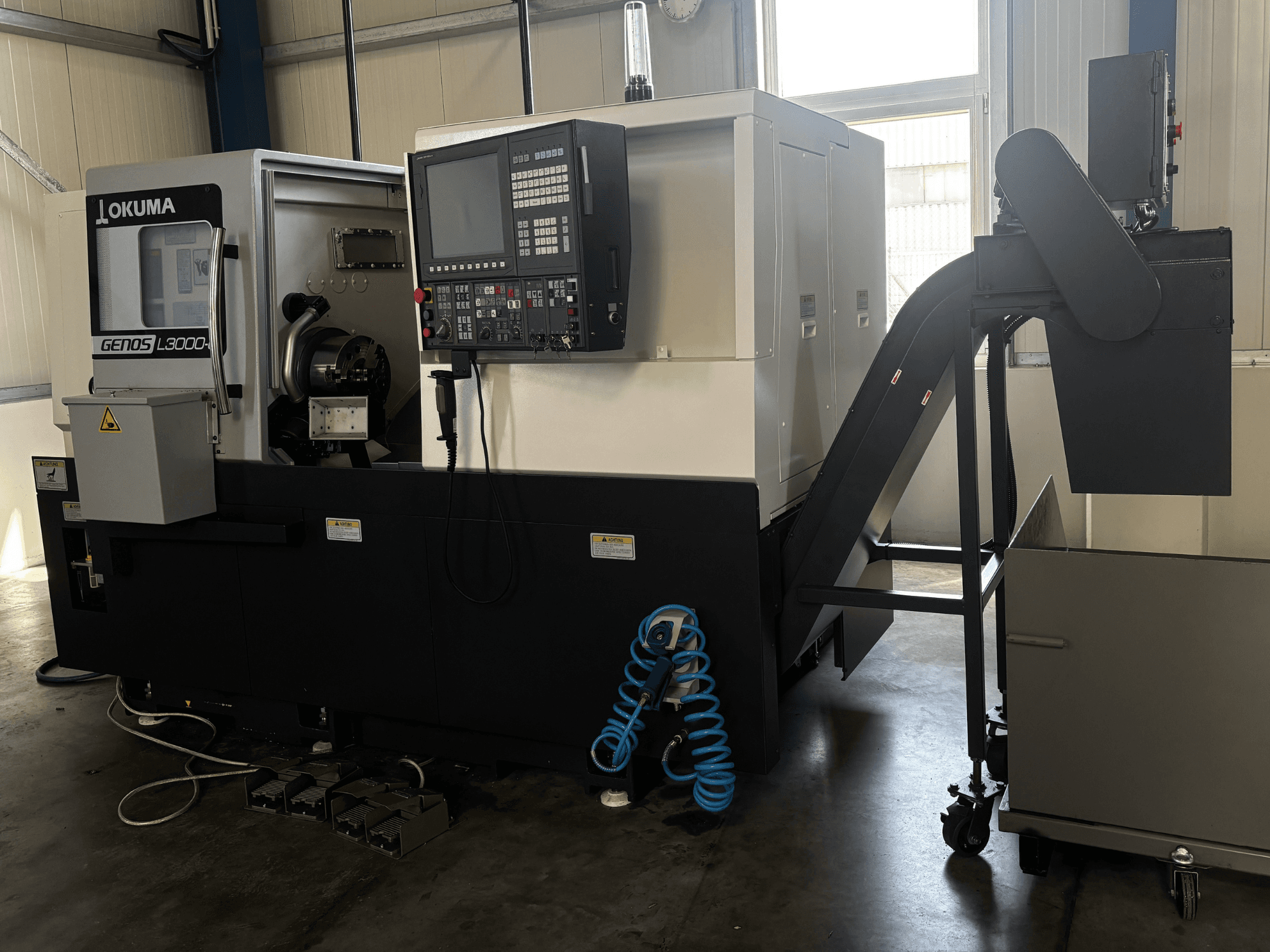 Okuma GENOS L3000-e horizontale draaibank, vooraanzicht, met bedieningspaneel, transportband en zichtbaar spilgebied.