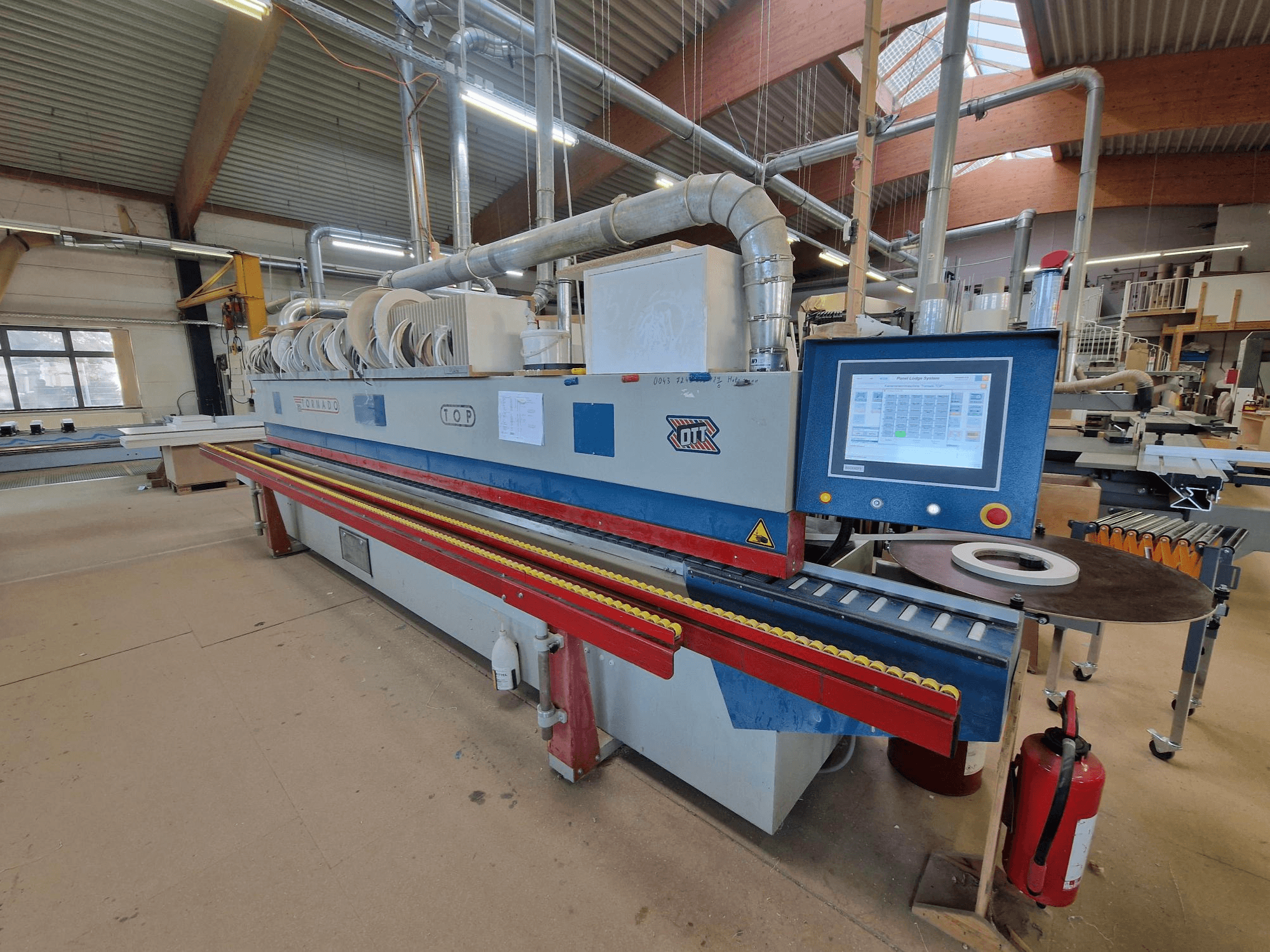 OTT Tornado-kantenlijmmachine, vooraanzicht, met het bedieningspaneel, de invoerrollen en het lijmaanbrenggebied.