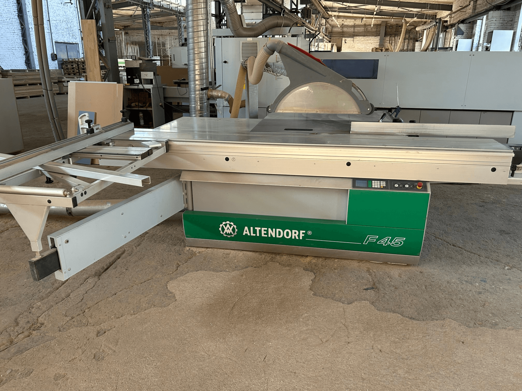 Altendorf F 45 paneelzaag, vooraanzicht, met de zaagtafel, de zaagbladbescherming en het bedieningspaneel op de groen-grijze machine.