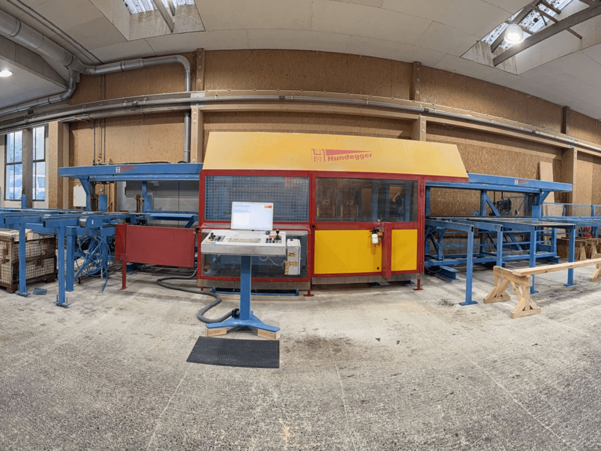 Vooraanzicht van de HUNDEGGER K2-4-450 complete houtproductielijn, met bedieningspaneel en transportsysteem.