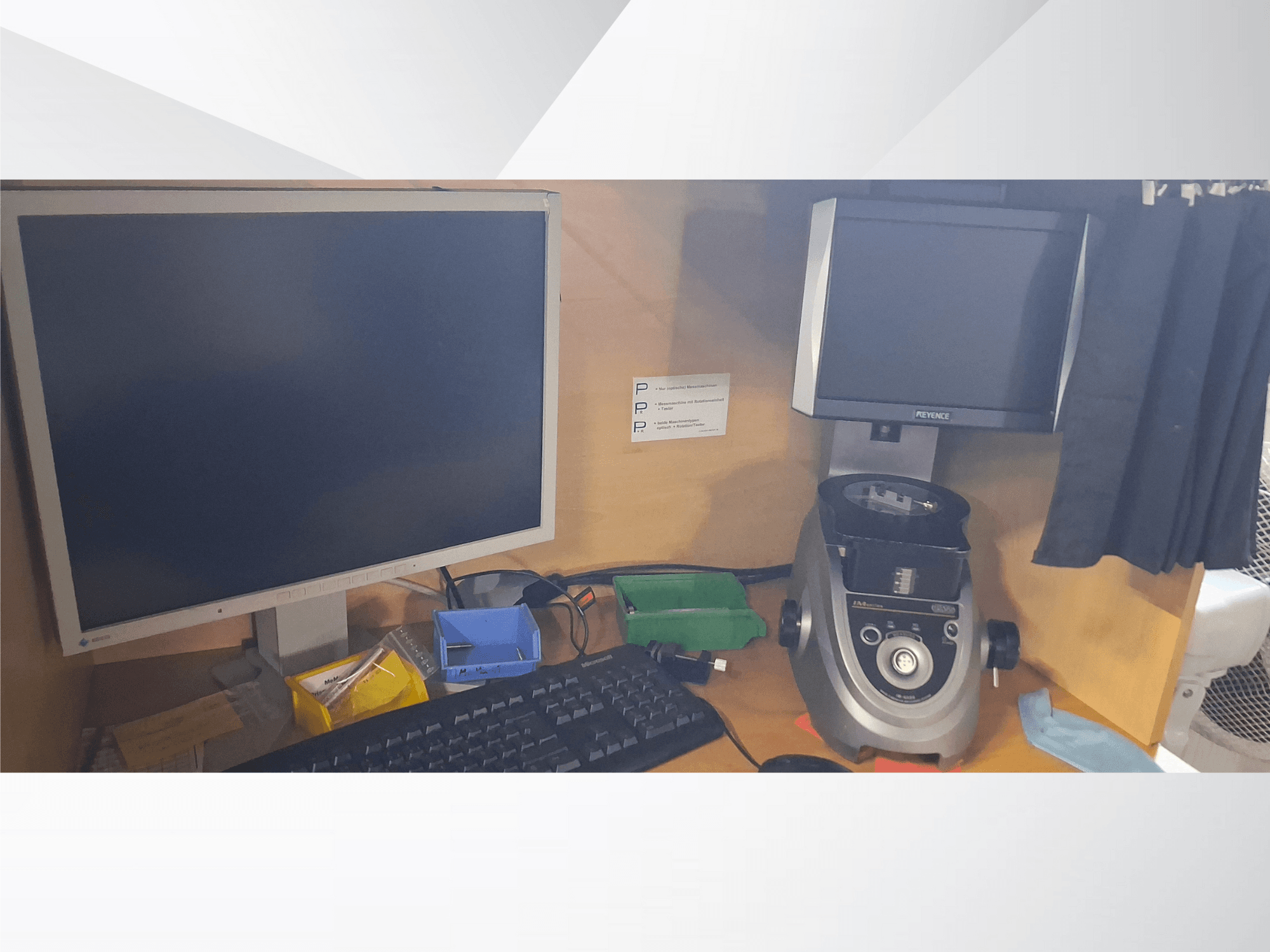 Computermonitor met toetsenbord, beeldscherm van het merk PEVA en een grijs laboratoriumapparaat op een houten bureau met verschillende laden en papierwerk.