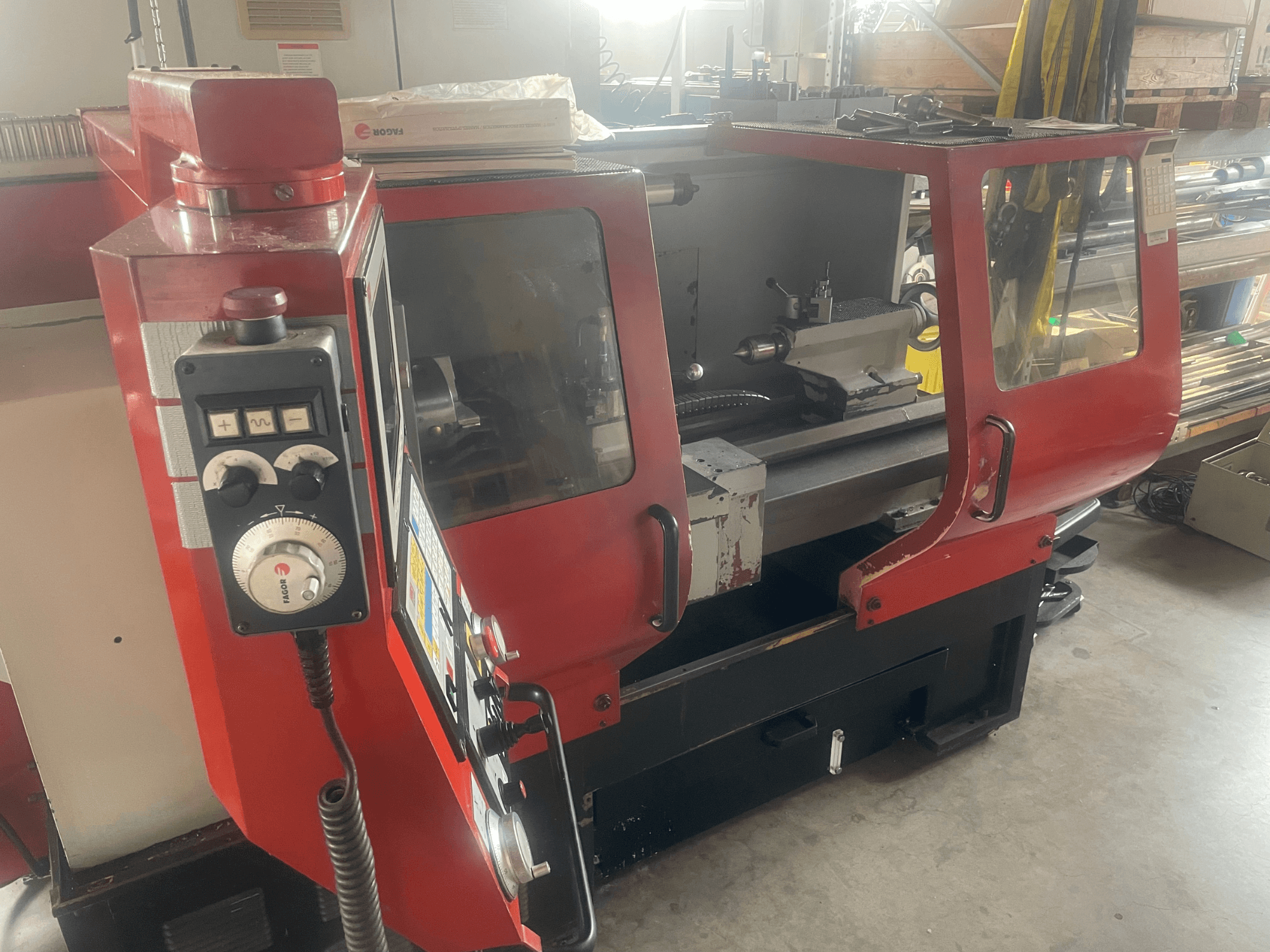 EMCO EMCOMAT 200X1000 horizontale draaibank, zijaanzicht, met weergave van de bedieningselementen, de behuizing met venster en de opstelling van de draaibank.