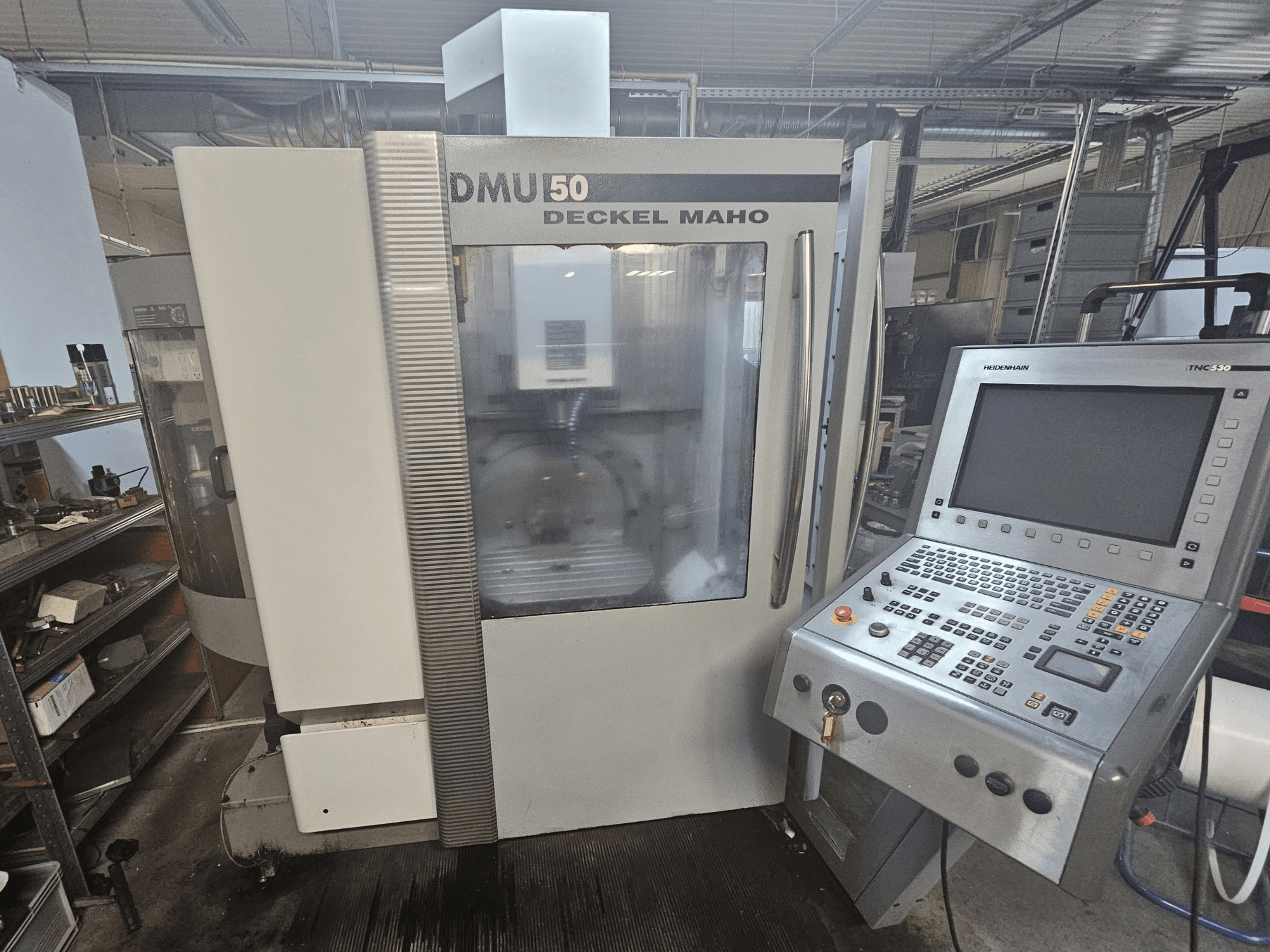 DMU 50 Deckel Maho CNC machine, vooraanzicht met bedieningspaneel en bedieningstoetsen zichtbaar, in een werkplaats.