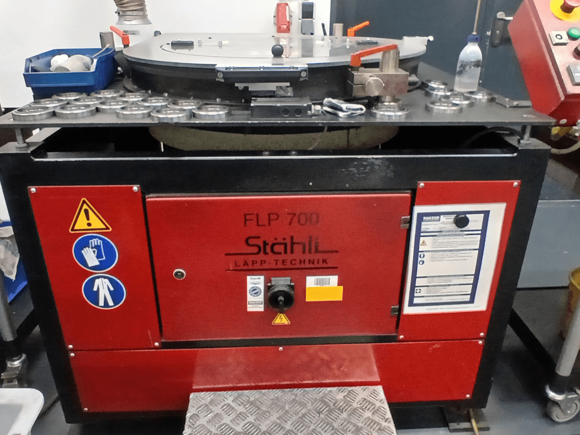 STAHLI FLP 700 werktuigmachine, vooraanzicht, met bedieningselementen, veiligheidswaarschuwingen en onderdelen op een metalen oppervlak.