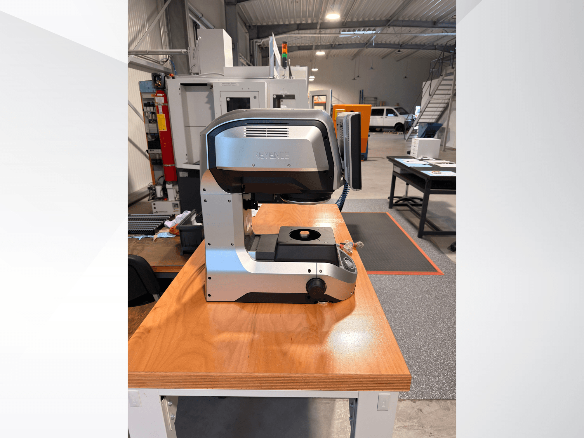 Vooraanzicht van de KEYENCE IM-8005 optische meetmachine op een houten tafel, waarbij het strakke ontwerp en de bedieningsinterface goed tot hun recht komen.