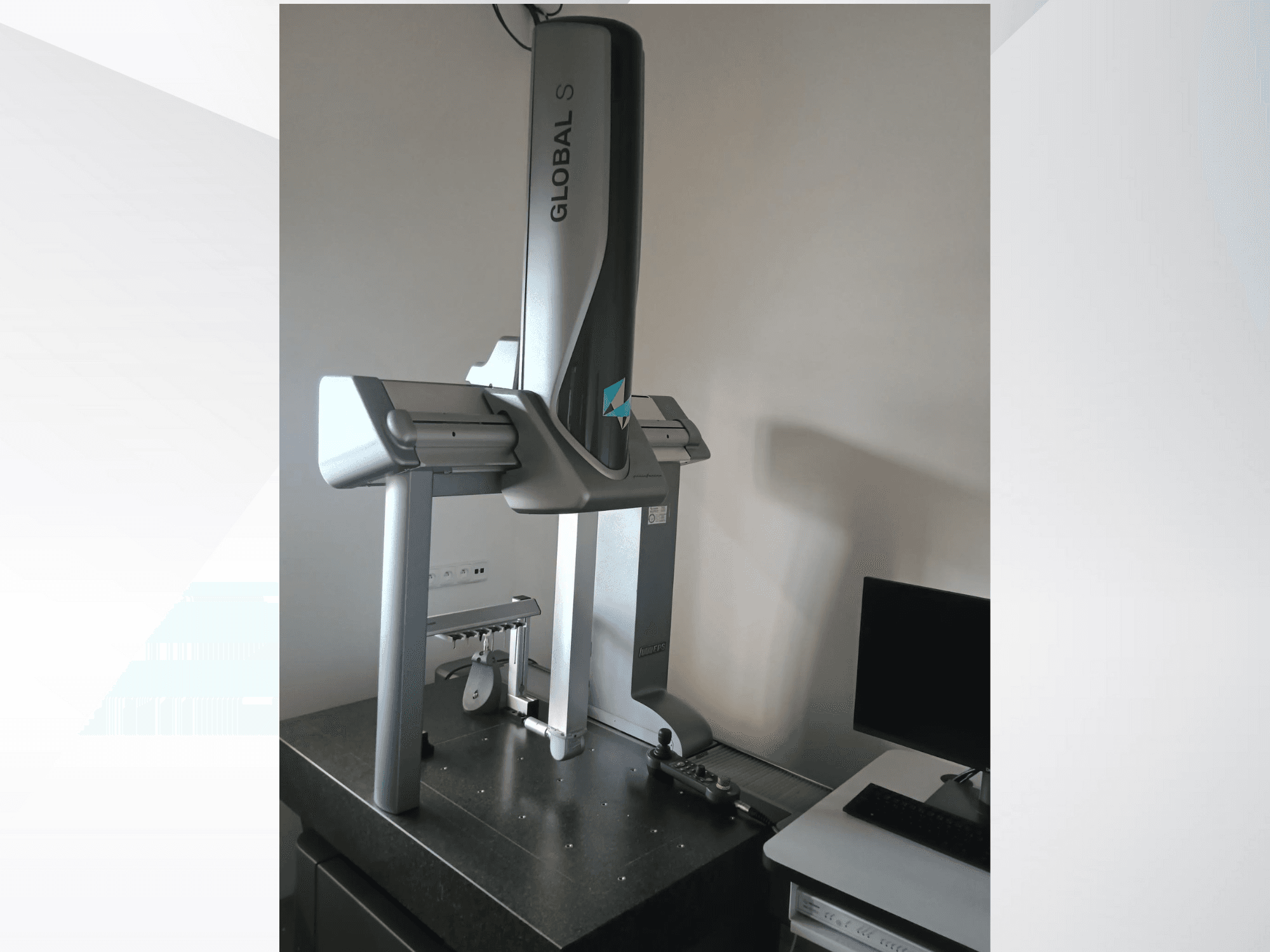 Global S coördinaten meetmachine getoond vanaf de voorkant, met een slank, zilverkleurig ontwerp op een donker oppervlak.