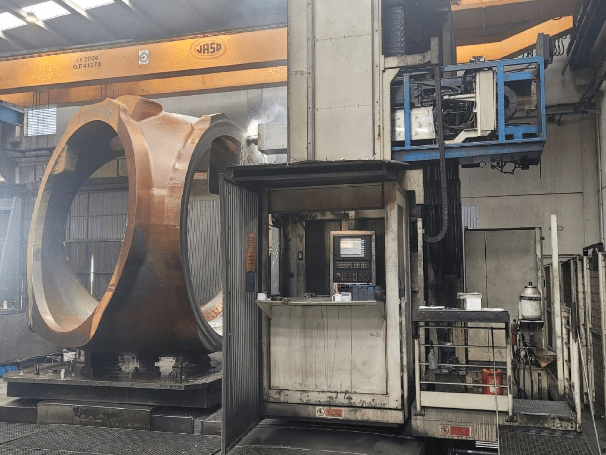 PAMA Speedram 1000 frees-draaicentrum, zijaanzicht, met een groot werkstuk en het bedieningspaneel in een industriële omgeving.