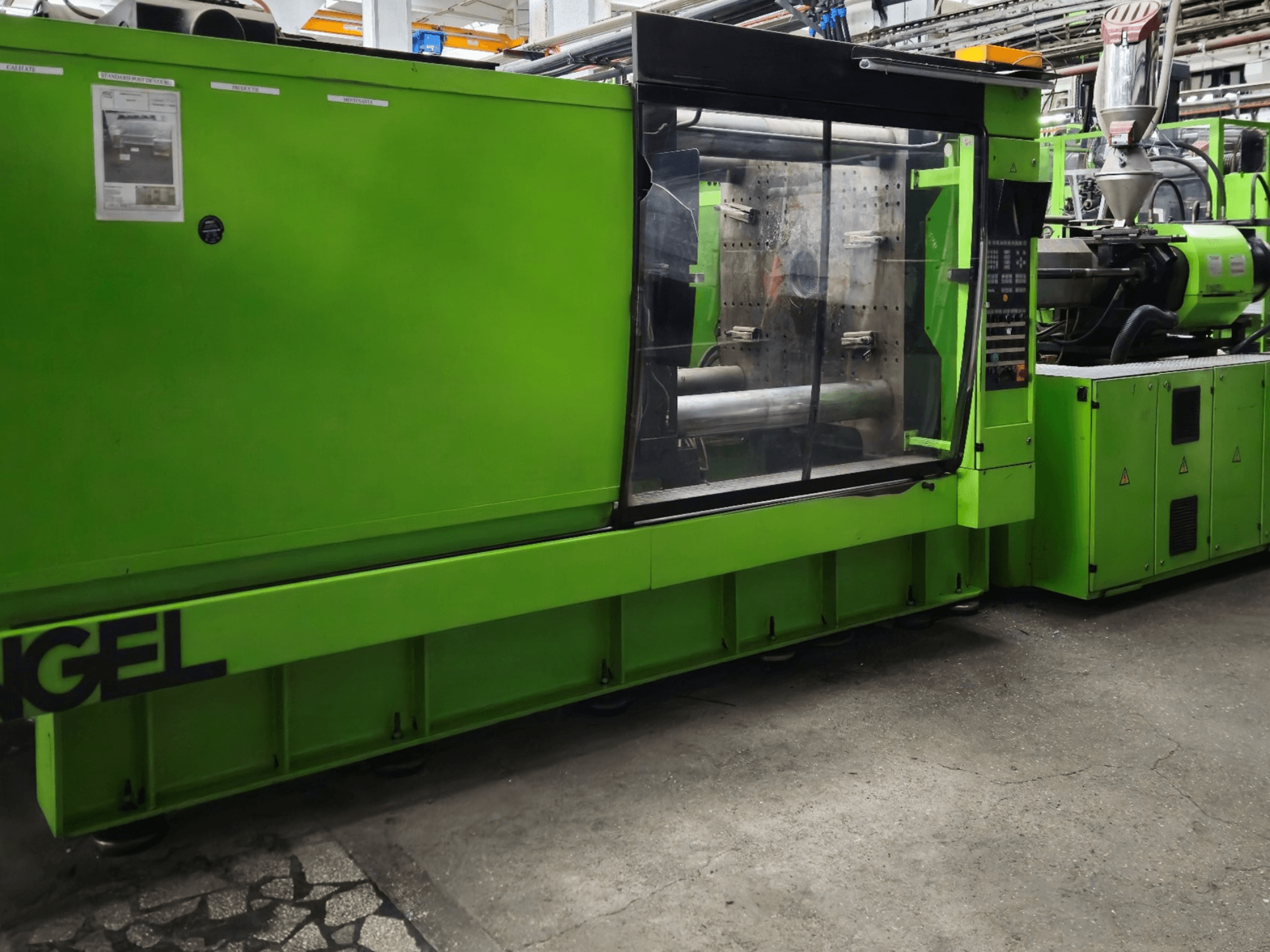 Groene Engel spuitgietmachine, zijaanzicht, met bedieningspaneel en groot kijkvenster.