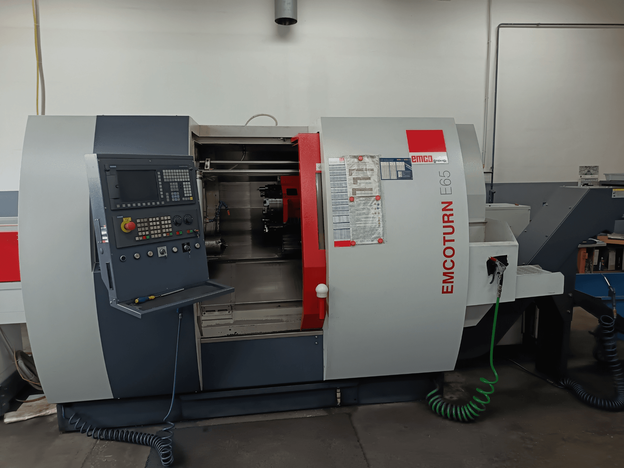 EMCO EMCOTURN E65 draaifreescentrum, vooraanzicht met bedieningspaneel, intern mechanisme en functies in een werkplaats.