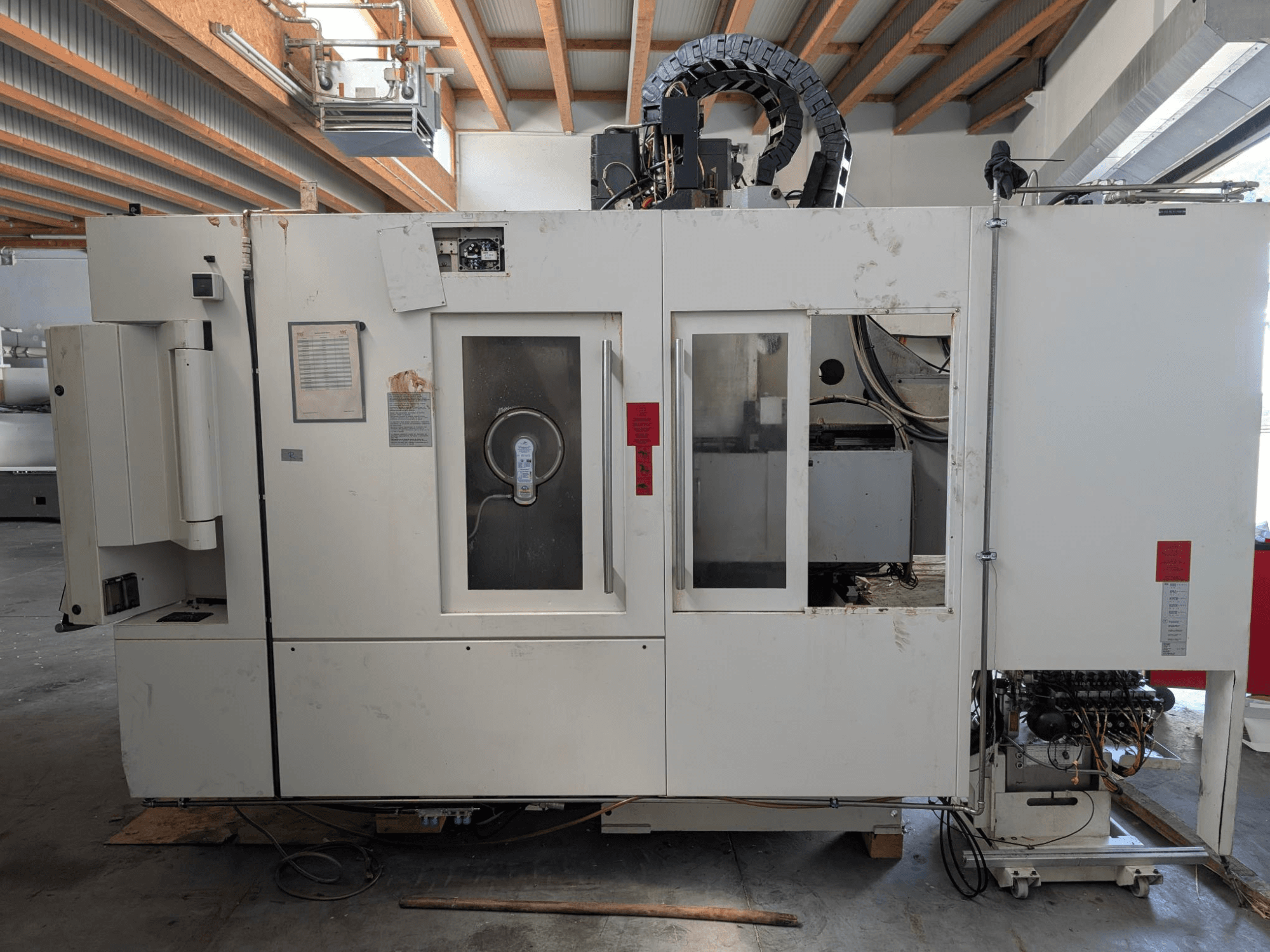 STAMA MC 326 verticaal bewerkingscentrum, zijaanzicht met bedieningspaneel, spindelgedeelte en diverse labels op de machine.