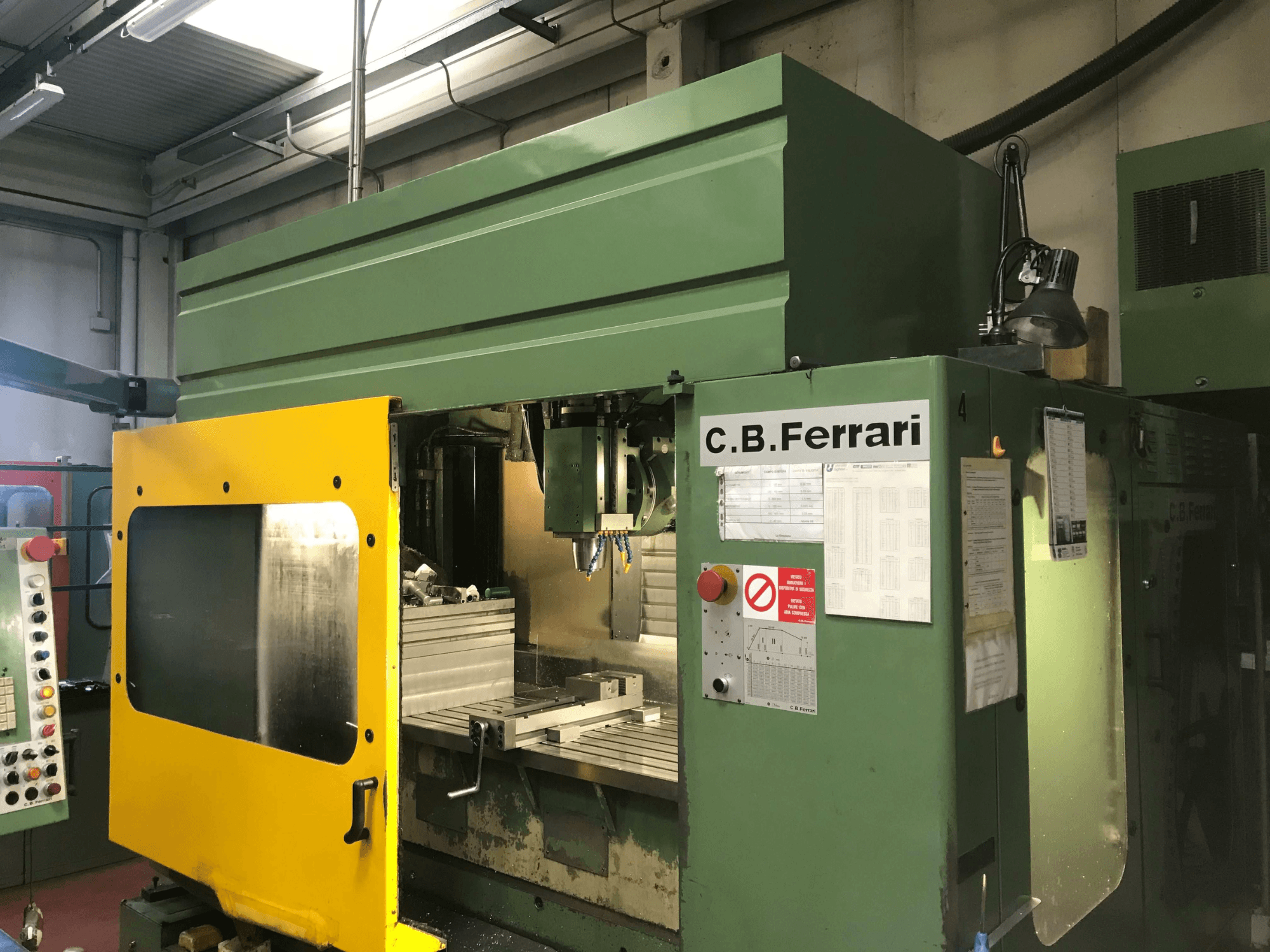 C.B. Ferrari B16 verticaal bewerkingscentrum, vooraanzicht met gele veiligheidsdeur, bedieningspaneel en zichtbaar bewerkingsgebied.