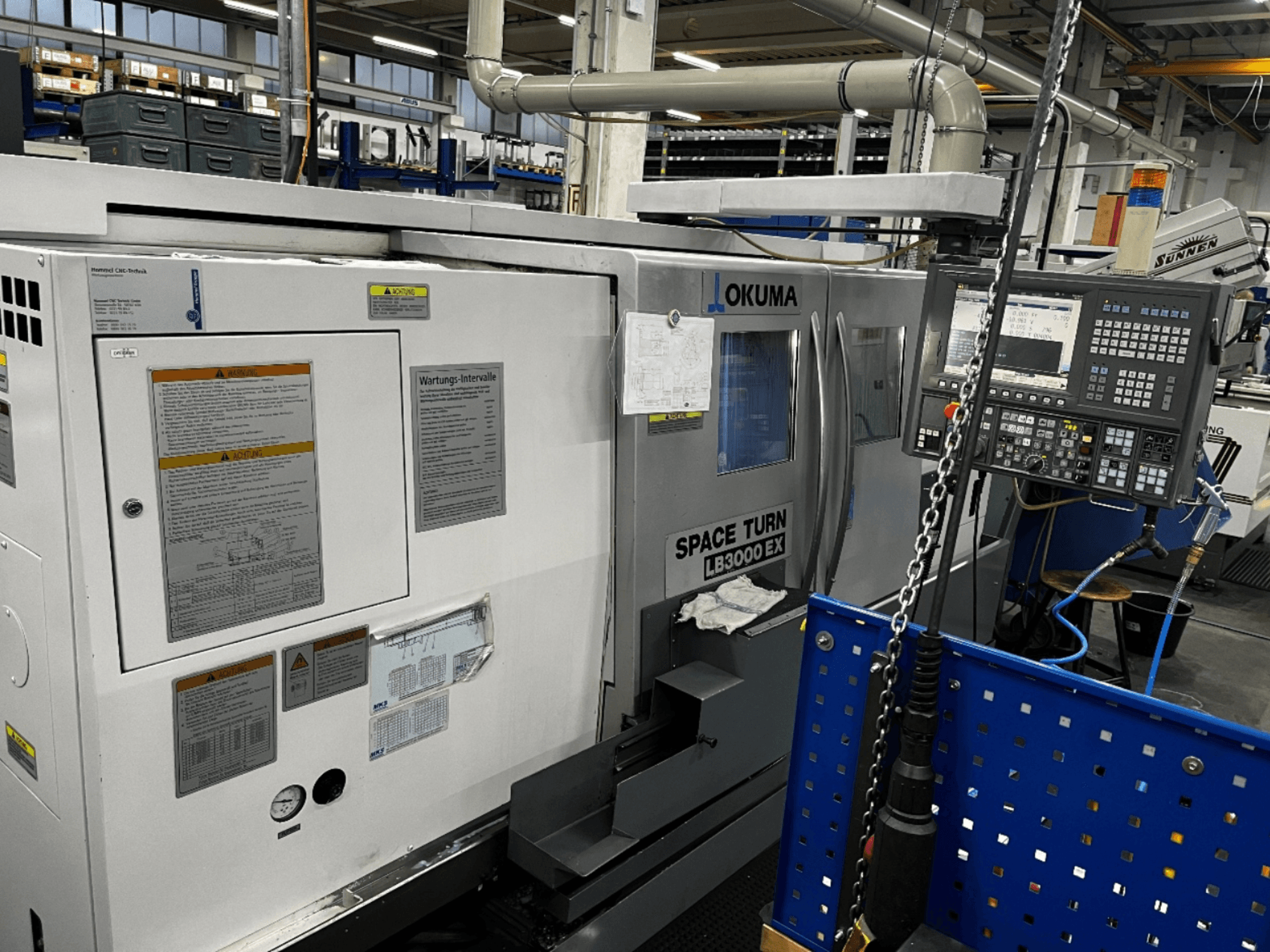 Okuma LB3000 EX horizontale draaimachine, vooraanzicht, met bedieningspaneel en veiligheidsinformatie aan de zijkant.