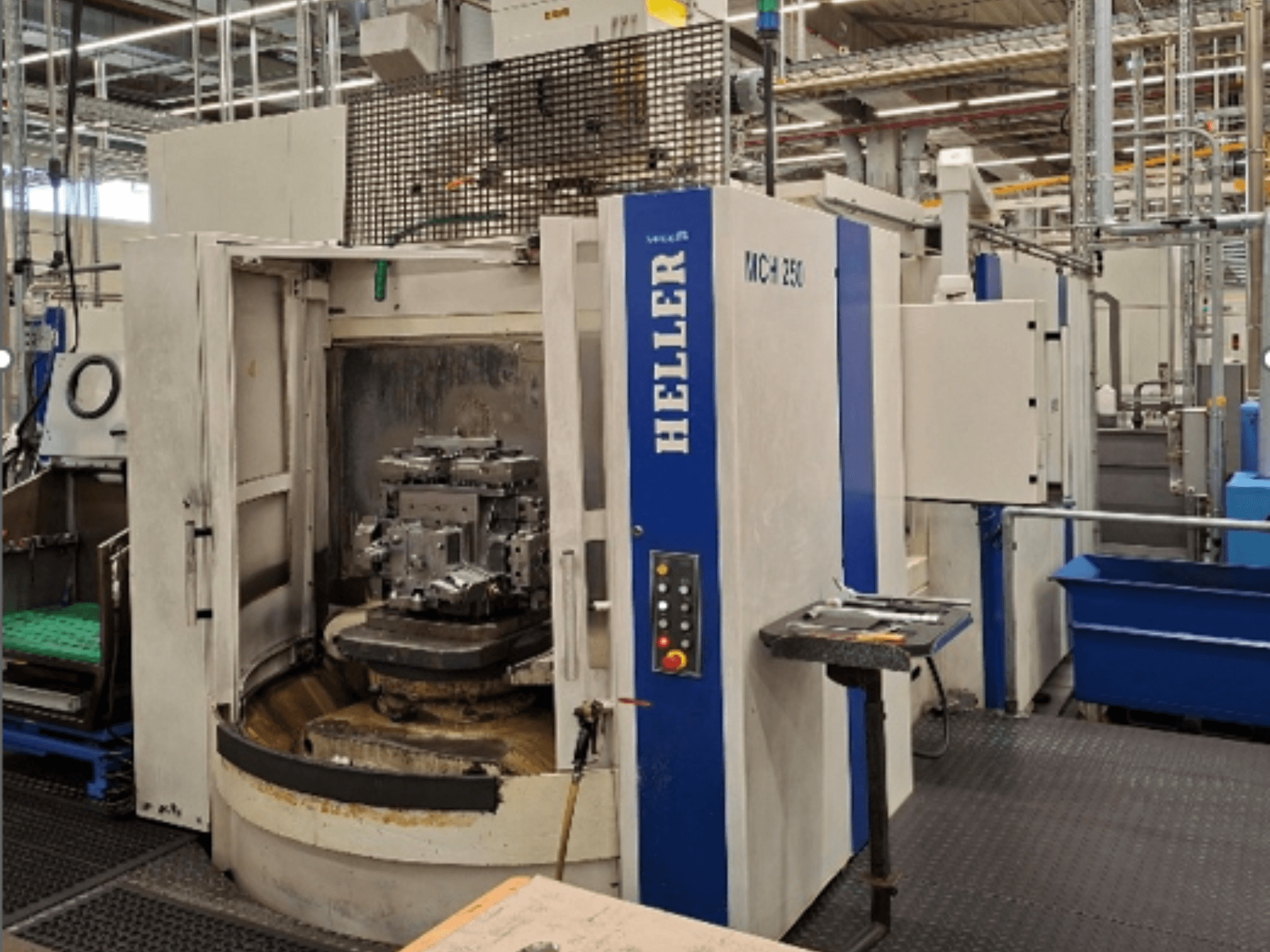 Het horizontale bewerkingscentrum Heller MCH 250 in vooraanzicht, met een werkstuk op een draaitafel en een bedieningspaneel.