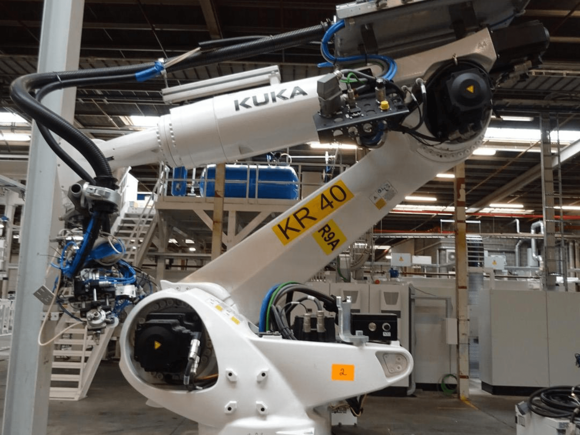 KUKA KR 120 R3100-2 robotarm in zijaanzicht, met het bedieningspaneel en de mechanische componenten, opgesteld in een industriële omgeving.