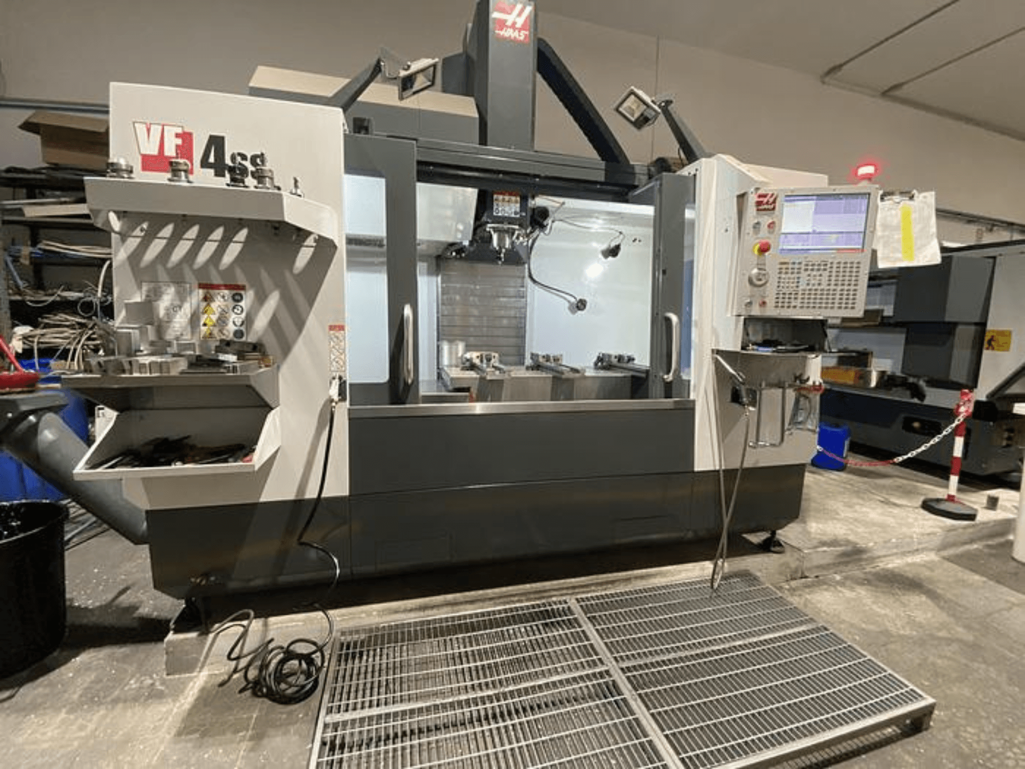 Haas VF-4SS CNC freesmachine, vooraanzicht, met gereedschapopslag, bedieningspaneel en zichtbaar werkgebied in een werkplaats.