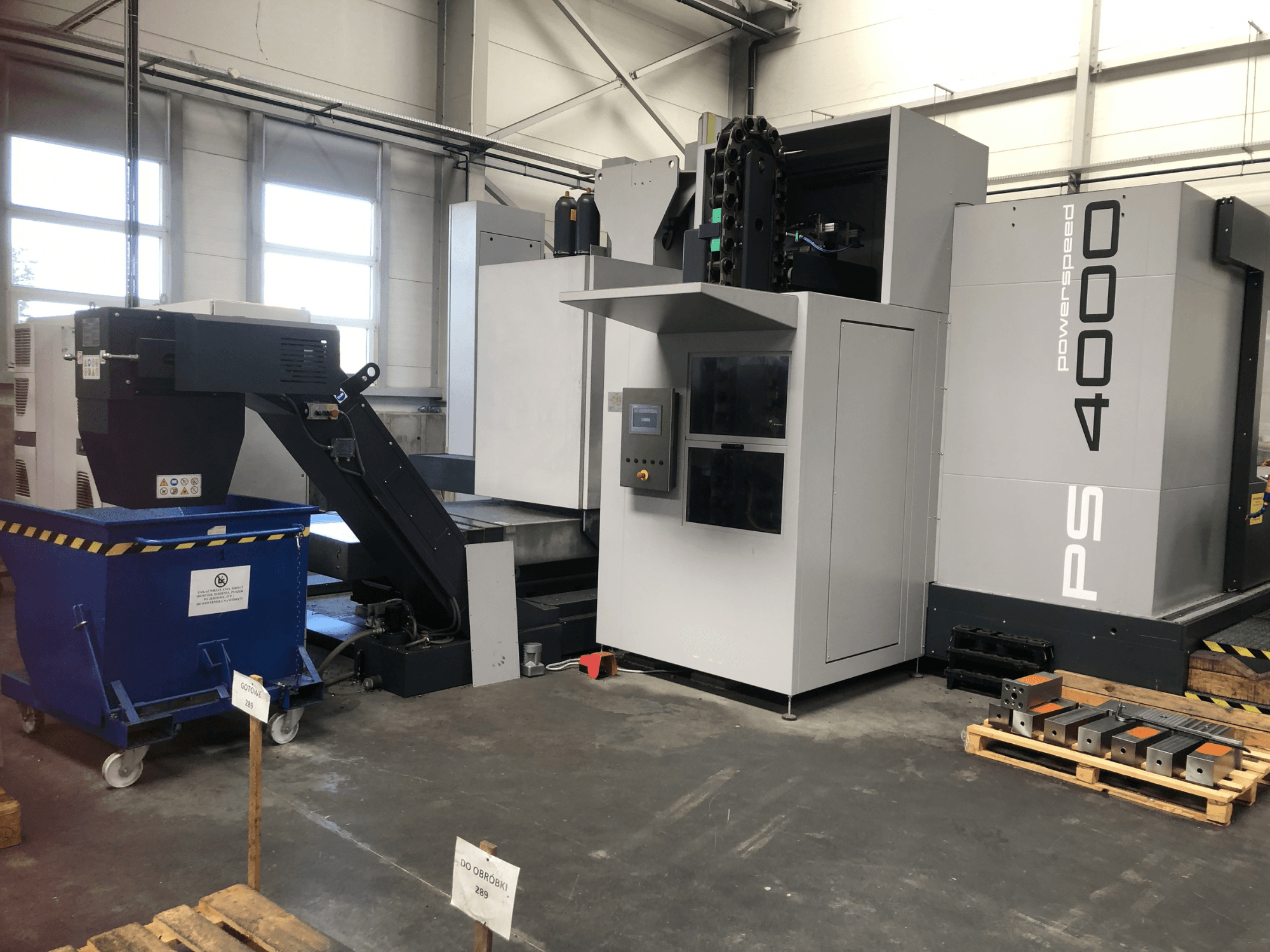 Het horizontale bewerkingscentrum SHW PowerSpeed 4000 in een fabrieksomgeving, met het bedieningspaneel, de transportband en de werkstukken.