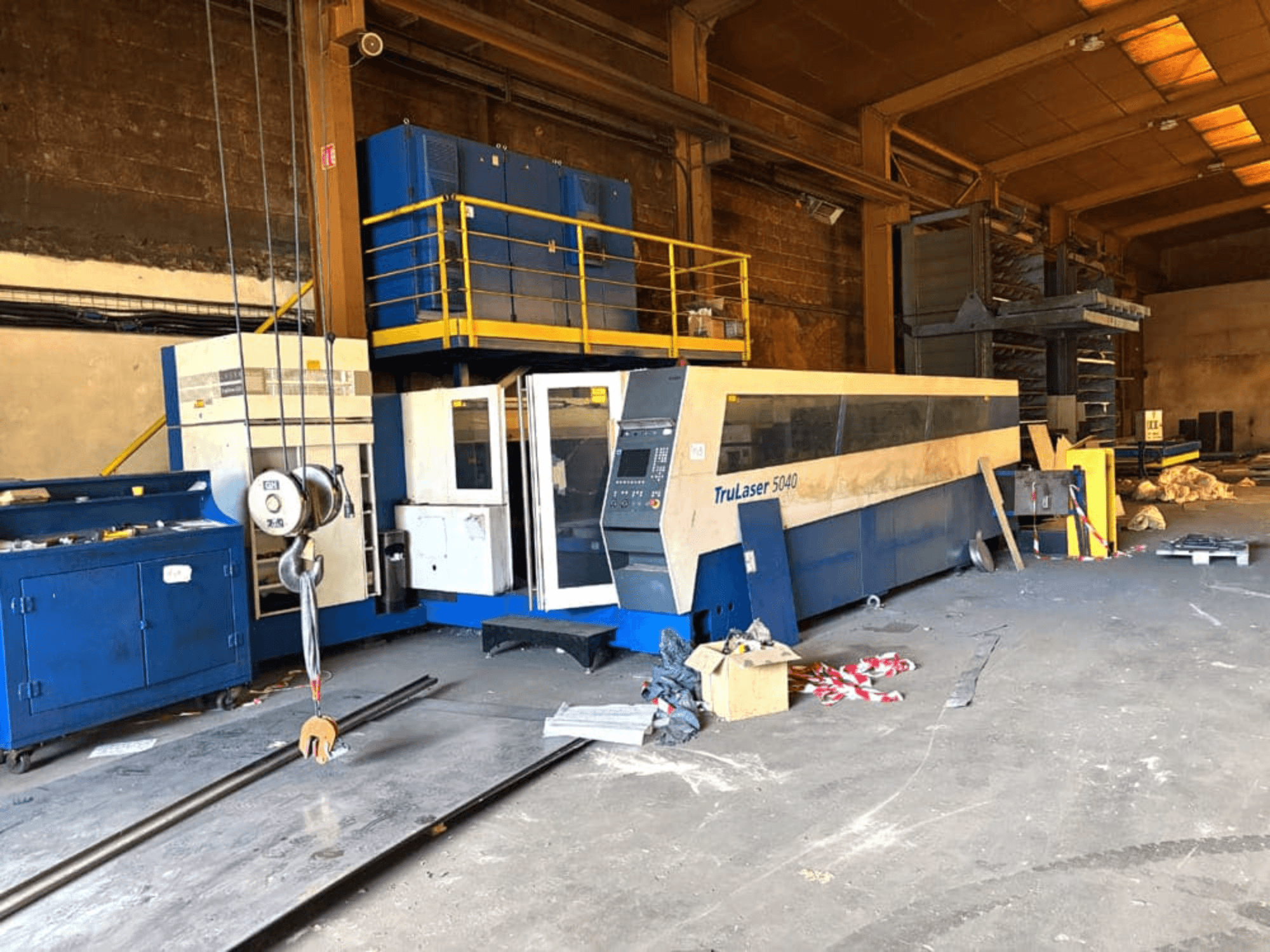 CO₂-lasersnijmachine van TRUMPF, model TRULASER 5040, afgebeeld in een werkplaats, schuin vooraanzicht met een rommelige achtergrond.