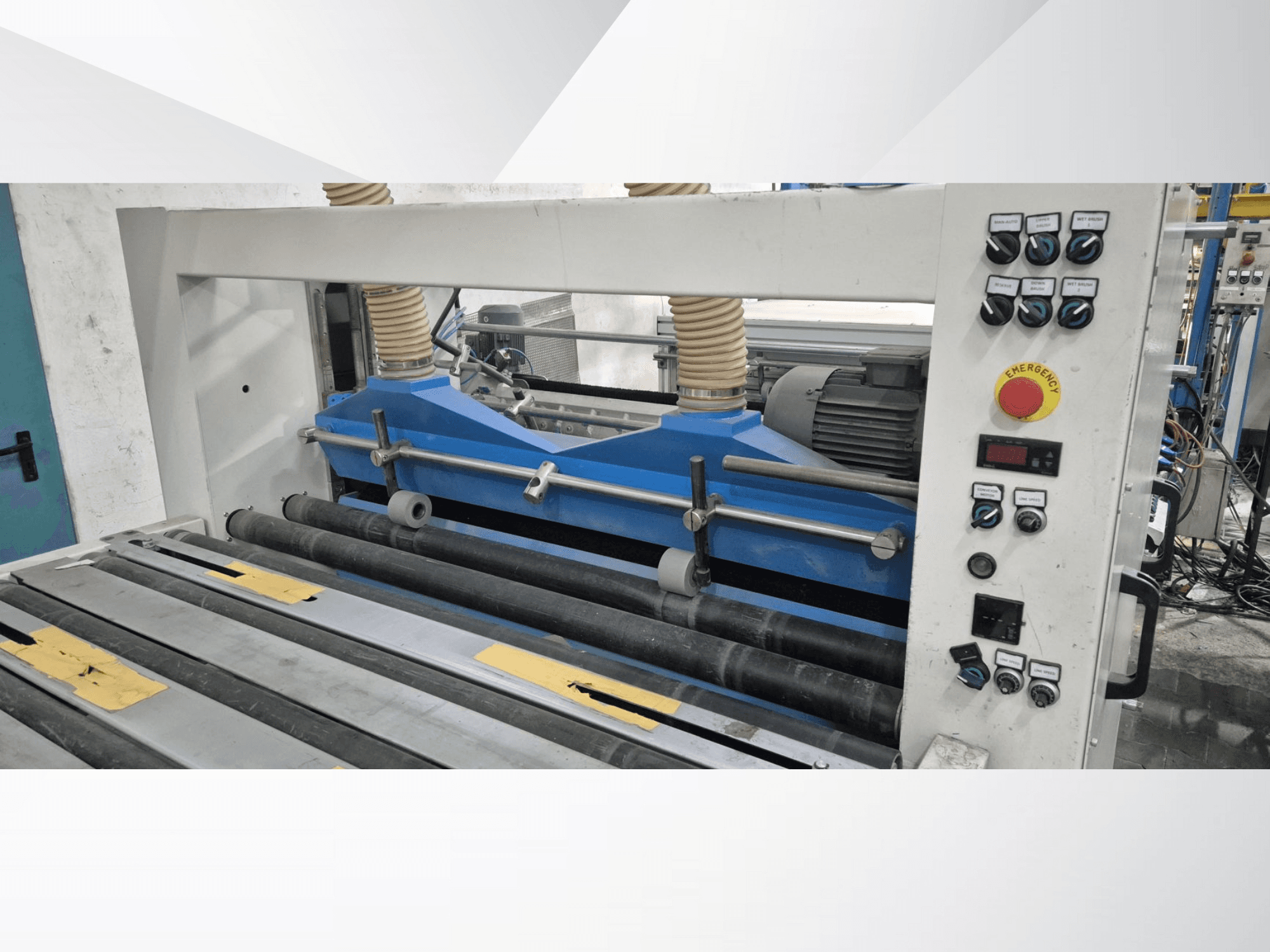 Industriële rolmachine met blauwe onderdelen, vooraanzicht, met bedieningspaneel en noodstopknop.