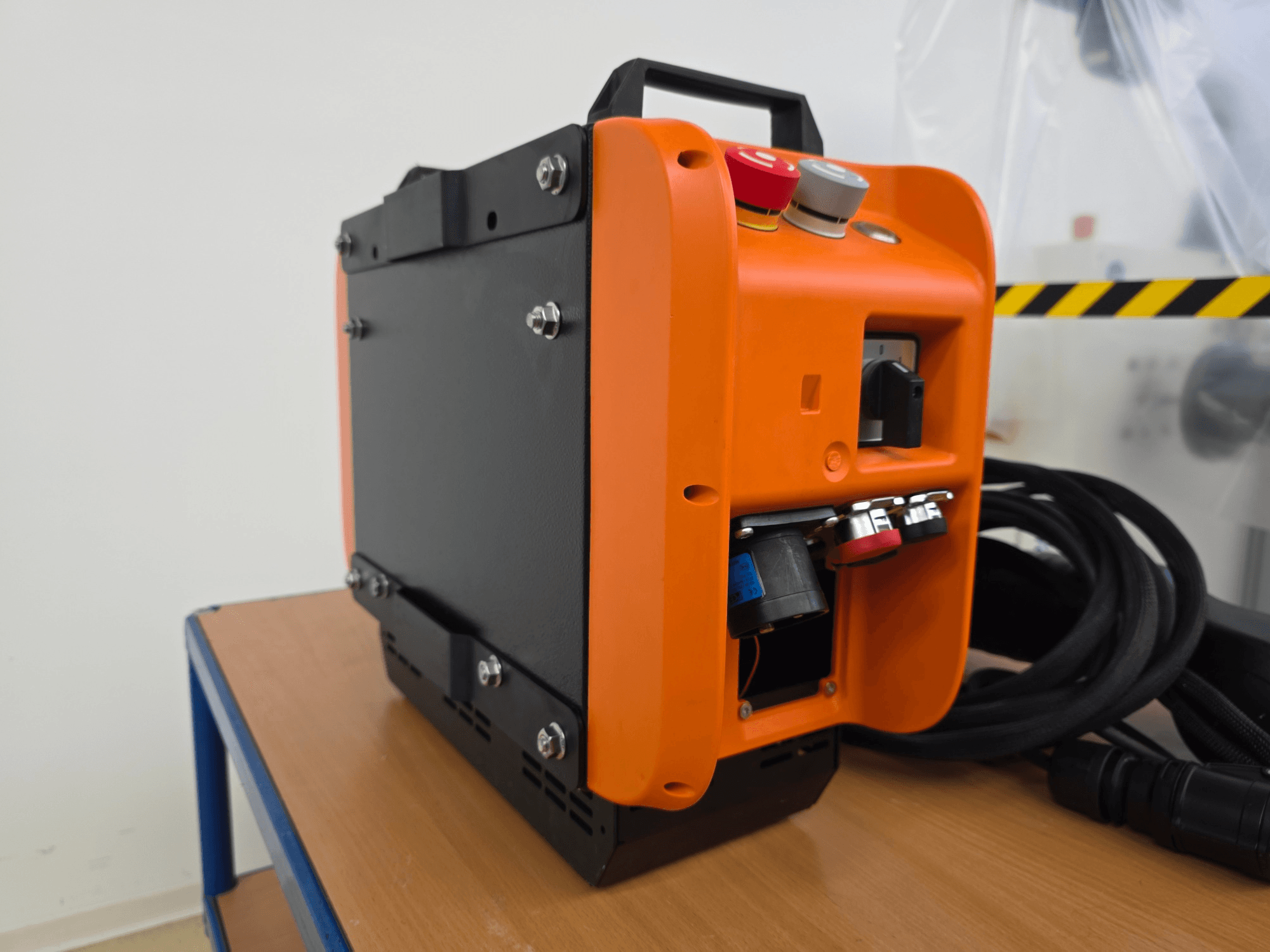 KASSOW ROBOTS KR1205 robot arm controller, zijaanzicht met oranje en zwart design, input/output poorten en kabels.