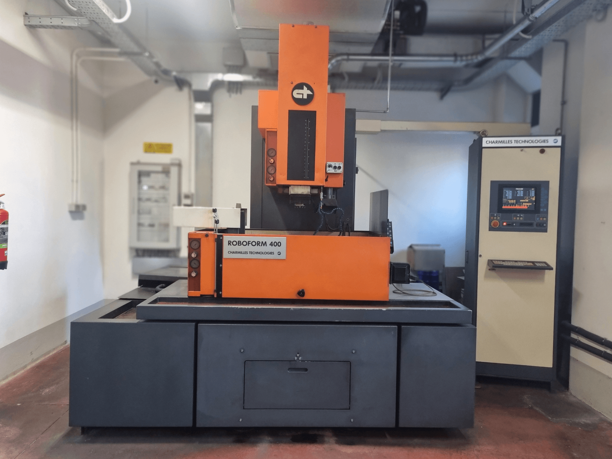 Roboforn 400 machine van Charmilles Technologies, vooraanzicht, met een oranje en grijs ontwerp, digitaal bedieningspaneel zichtbaar.