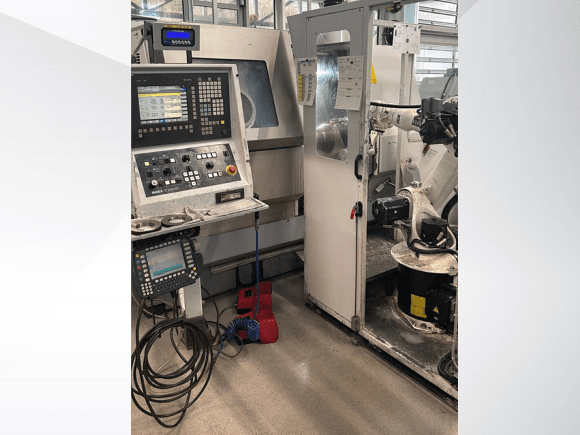 Vooraanzicht van Index G 200 RATIO LINE draai-freescentrum, met bedieningspaneel, robotarm en operationele werkruimte.