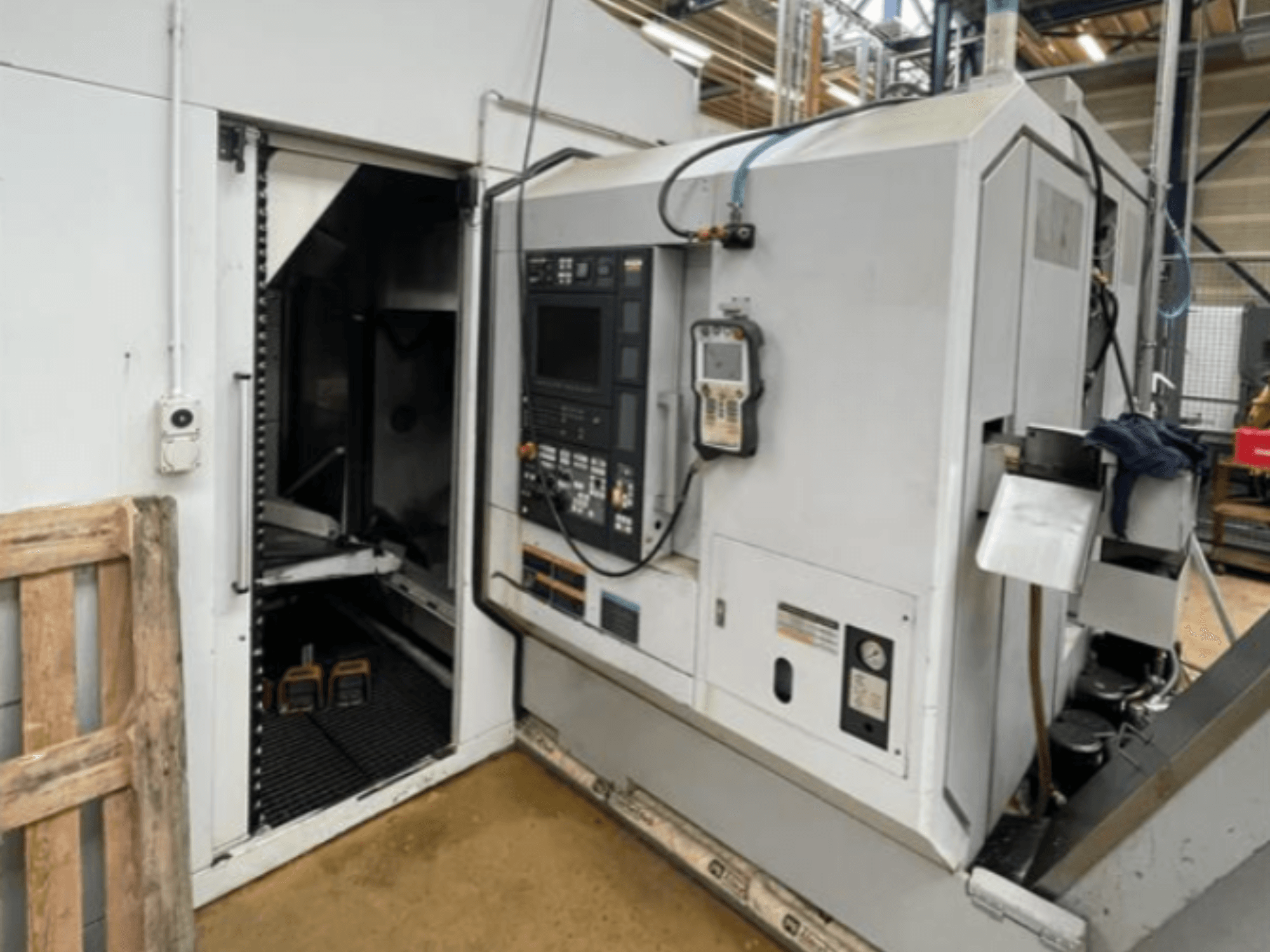 DMG Mori Seiki NZ2000T3Y2 horizontale draaimachine, zijaanzicht met bedieningspaneel en machine-interieur.