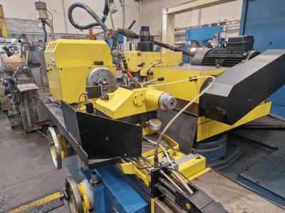 Gele industriële machine met een zwart gedeelte, met een wijzerplaat en slangen, gezien vanaf de voorkant onder een lichte hoek.