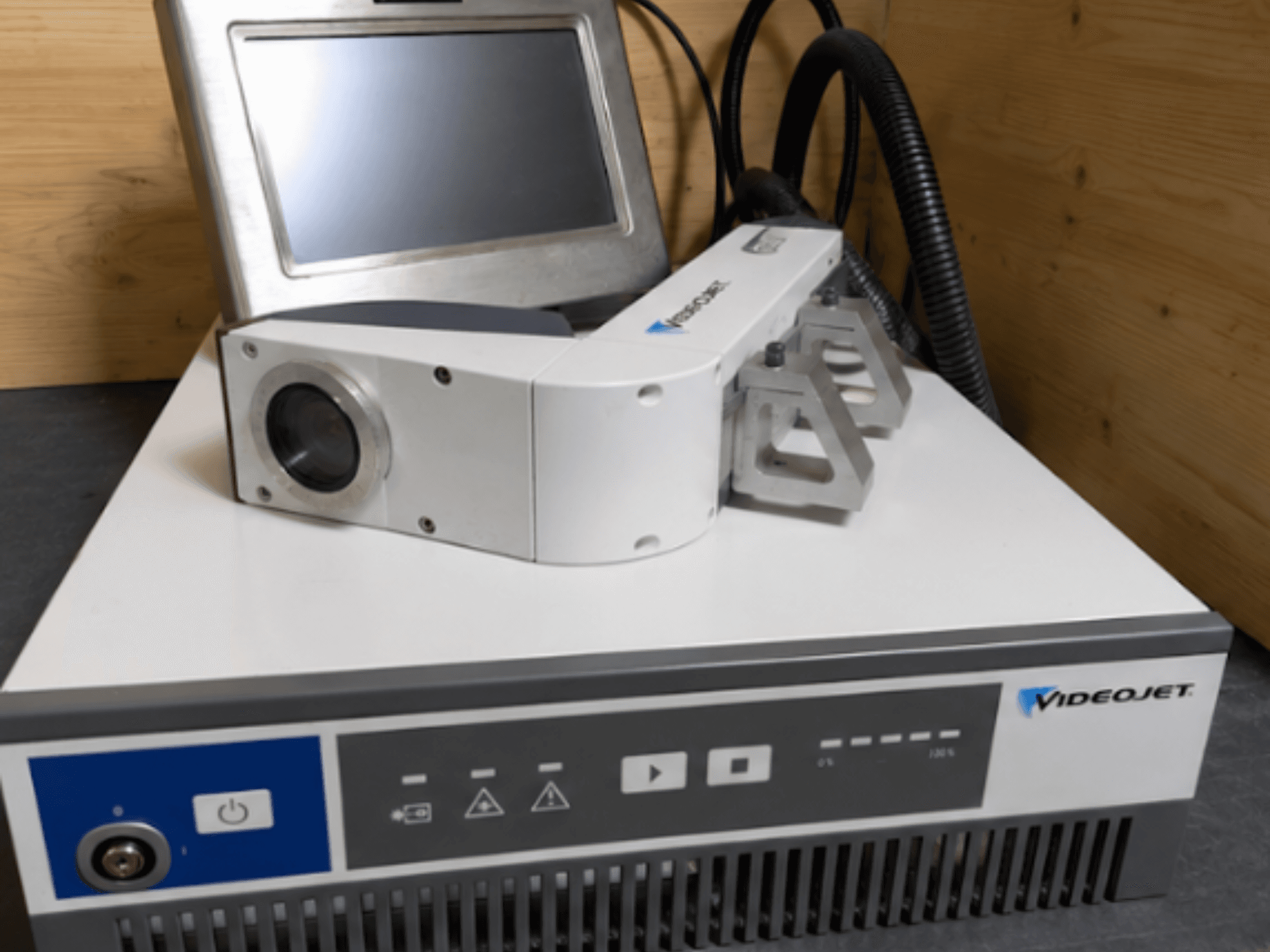Videojet 7230 lasergraveermachine, vooraanzicht, met bedieningspaneel en laserkop met lens en opzetstuk.