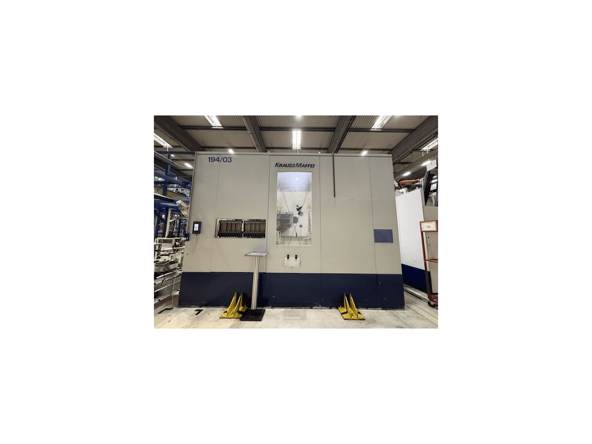 Krauss Maffei 4000-24500 MC hydraulische spuitgietmachine, vooraanzicht met bedieningspaneel en bedieningsruimte.