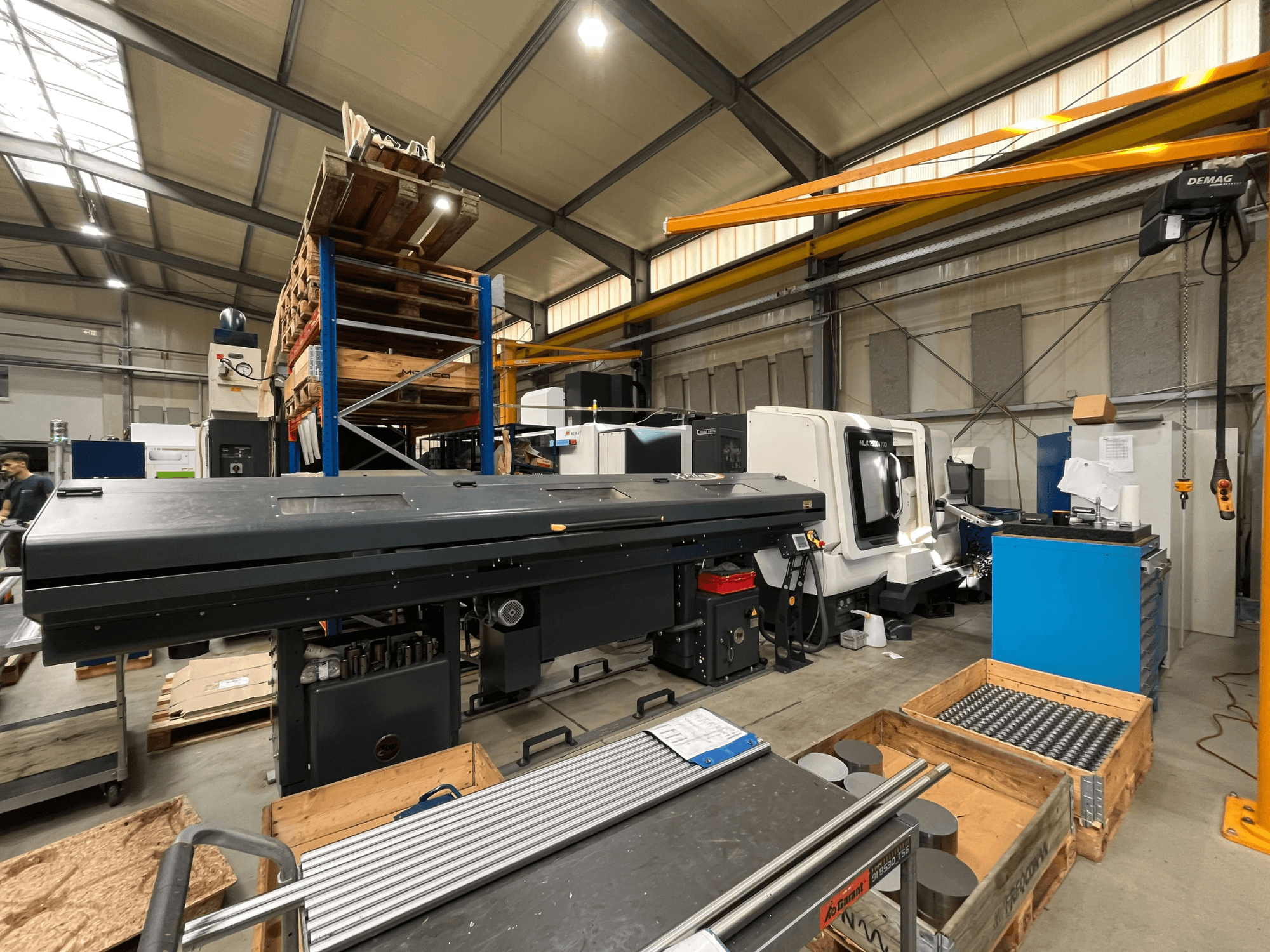 DMG MORI MORI NLX 2500/700 SY horizontale draaibank in een werkplaats, gezien vanaf de zijkant, met op de achtergrond opslagruimte en gereedschap.