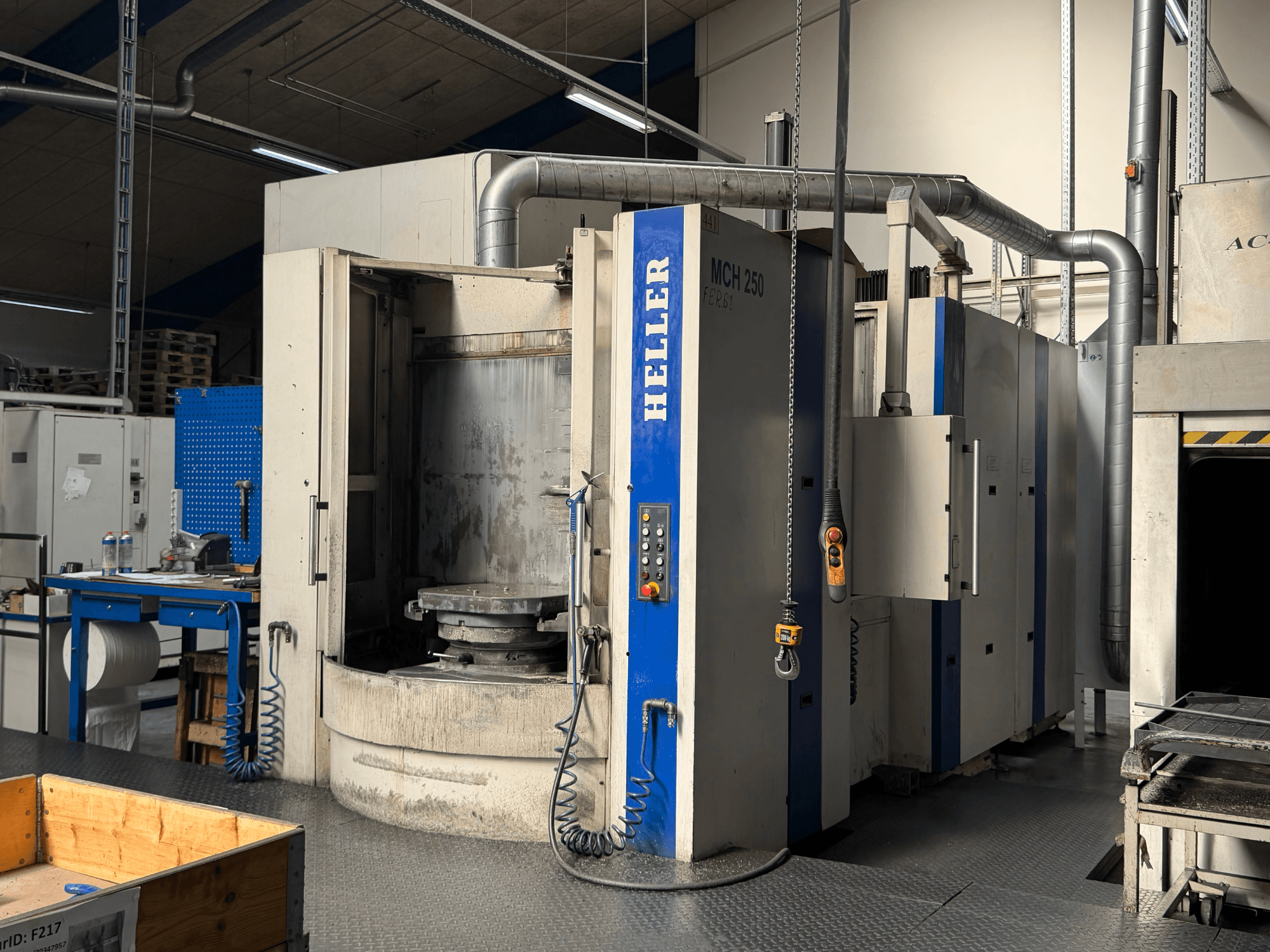 Vooraanzicht van HELLER MCH 250 horizontaal bewerkingscentrum met bedieningspaneel, grote draaitafel en industriële omgeving.