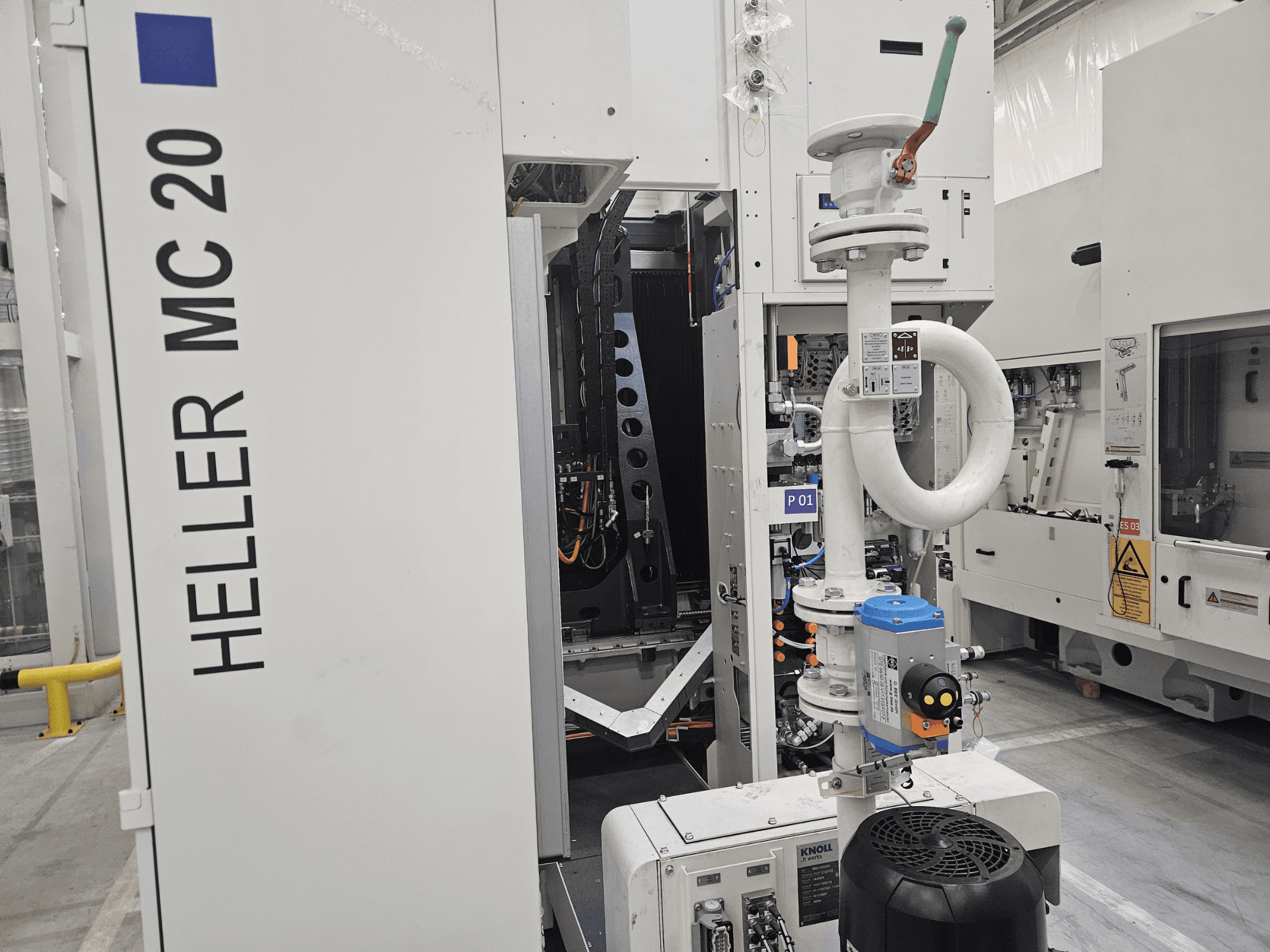 Heller MC 20 machine in een fabrieksomgeving, met het bedieningspaneel en de mechanische onderdelen in zijaanzicht.